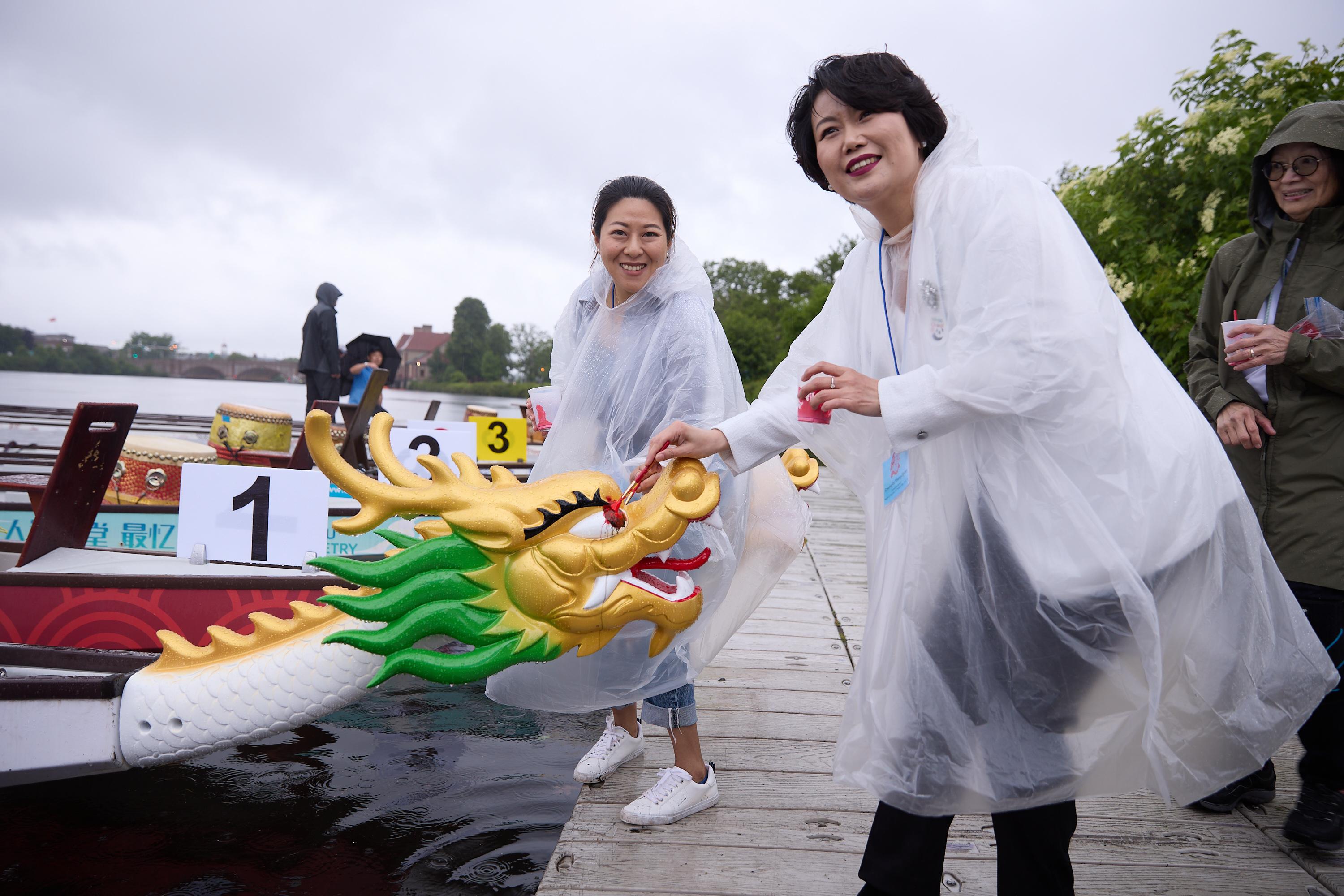 The 45th Boston Hong Kong Dragon Boat Festival was held on June 9 (Boston time). Picture shows the Director of the Hong Kong Economic and Trade Office, New York, Ms Maisie Ho (left), with the Cultural Counselor of the Consulate General of People's Republic of China in New York, Ms Shang Jiyuan (right), dotting the eyes of the Brand Hong Kong dragon boat. 