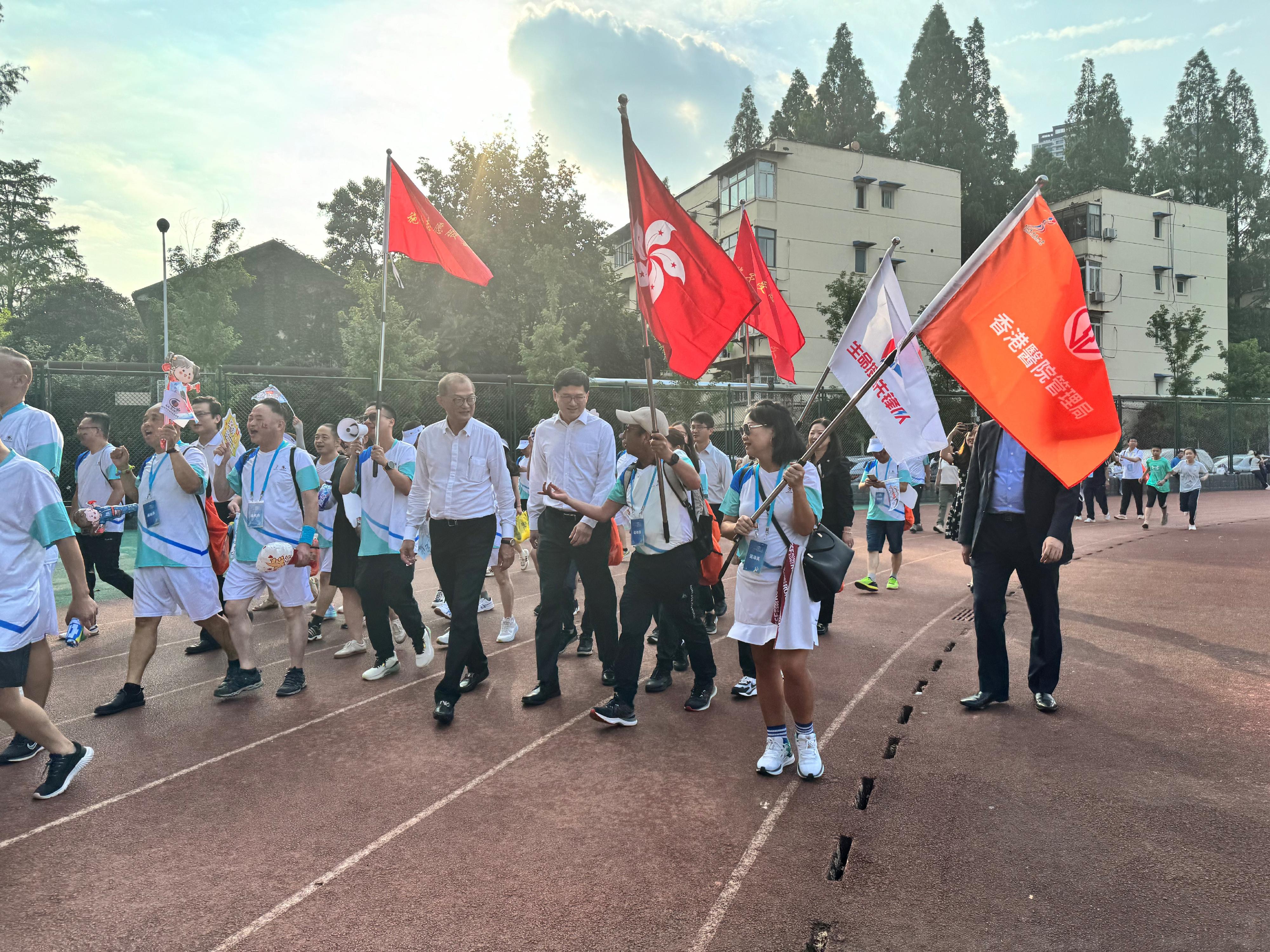 医务卫生局局长卢宠茂教授今日（六月十一日）在武汉出席由中国器官移植发展基金会主办的「中国器官捐献日」主题宣传活动暨第八届中国移植运动会。图示卢宠茂教授（右四）和医院管理局行政总裁高拔升医生（右三）与香港运动员交谈。

