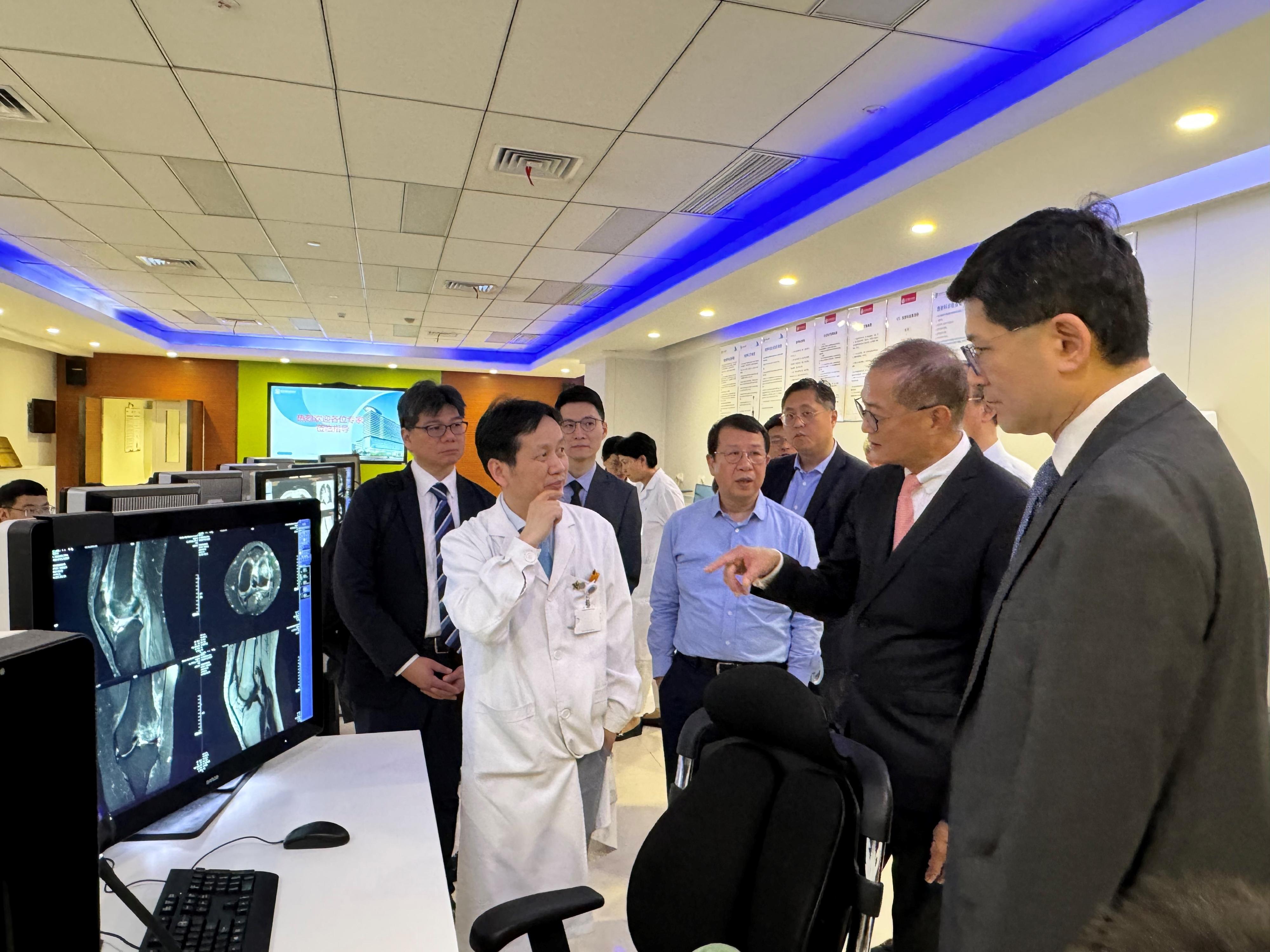 The Secretary for Health, Professor Lo Chung-mau, led a delegation to visit the Wuhan Asia General Hospital today (June 11). Photo shows Professor Lo (second right) and the Chief Executive of the Hospital Authority, Dr Tony Ko (first right), accompanied by the Chairman of the Hong Kong Asia Medical Group, Mr Tse Chun-ming (fourth right), learning about the hospital's facilities.