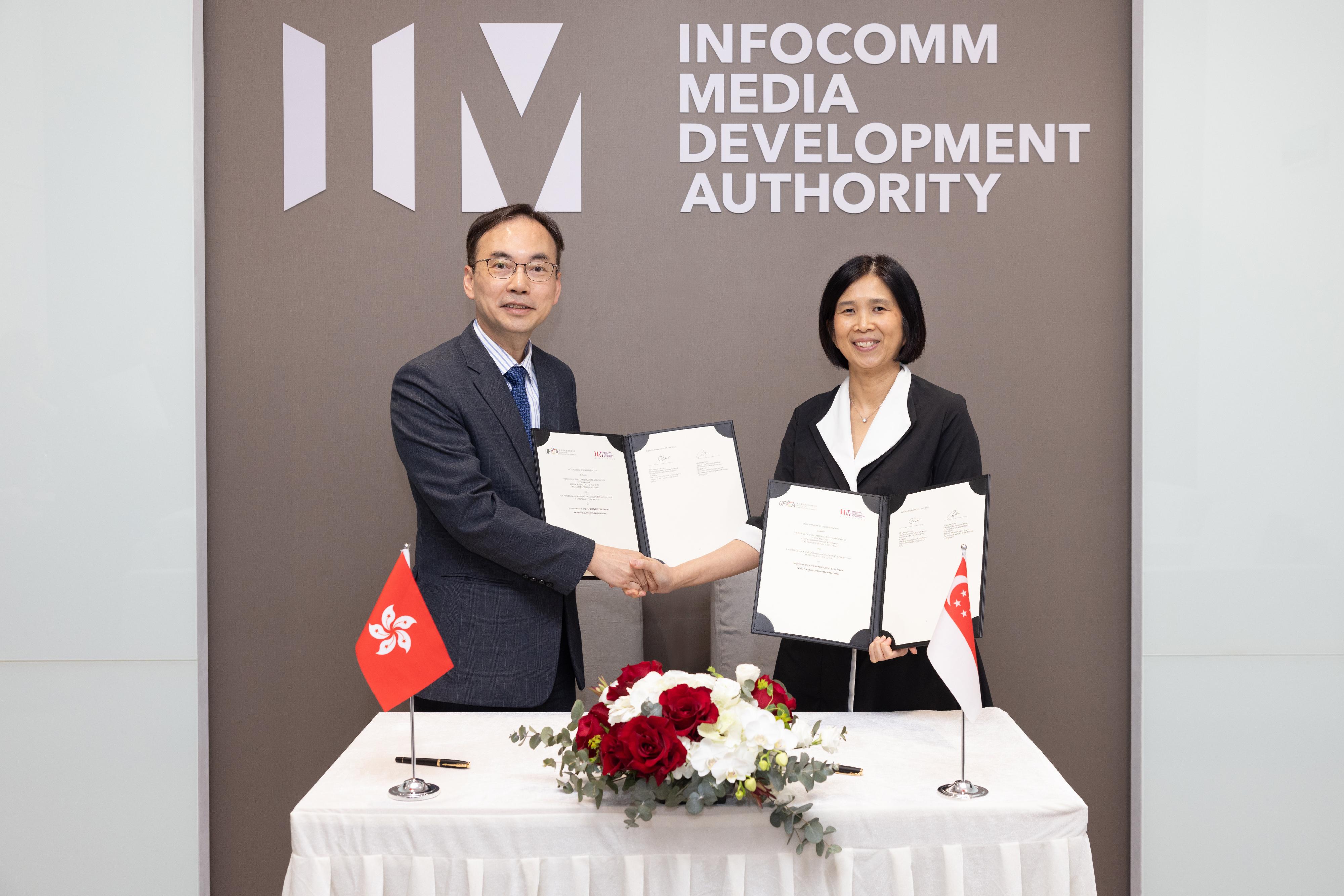 The Office of the Communications Authority of Hong Kong and the Infocomm Media Development Authority (IMDA) of Singapore signed a Memorandum of Understanding in Singapore today (June 11) to further strengthen co-operation in combating scam calls and messages as well as managing spam communications. Photo shows the Director-General of Communications, Mr Chaucer Leung (left), and the Deputy Chief Executive and Director-General (Telecoms and Post) of the IMDA, Ms Aileen Chia (right), at the signing ceremony.