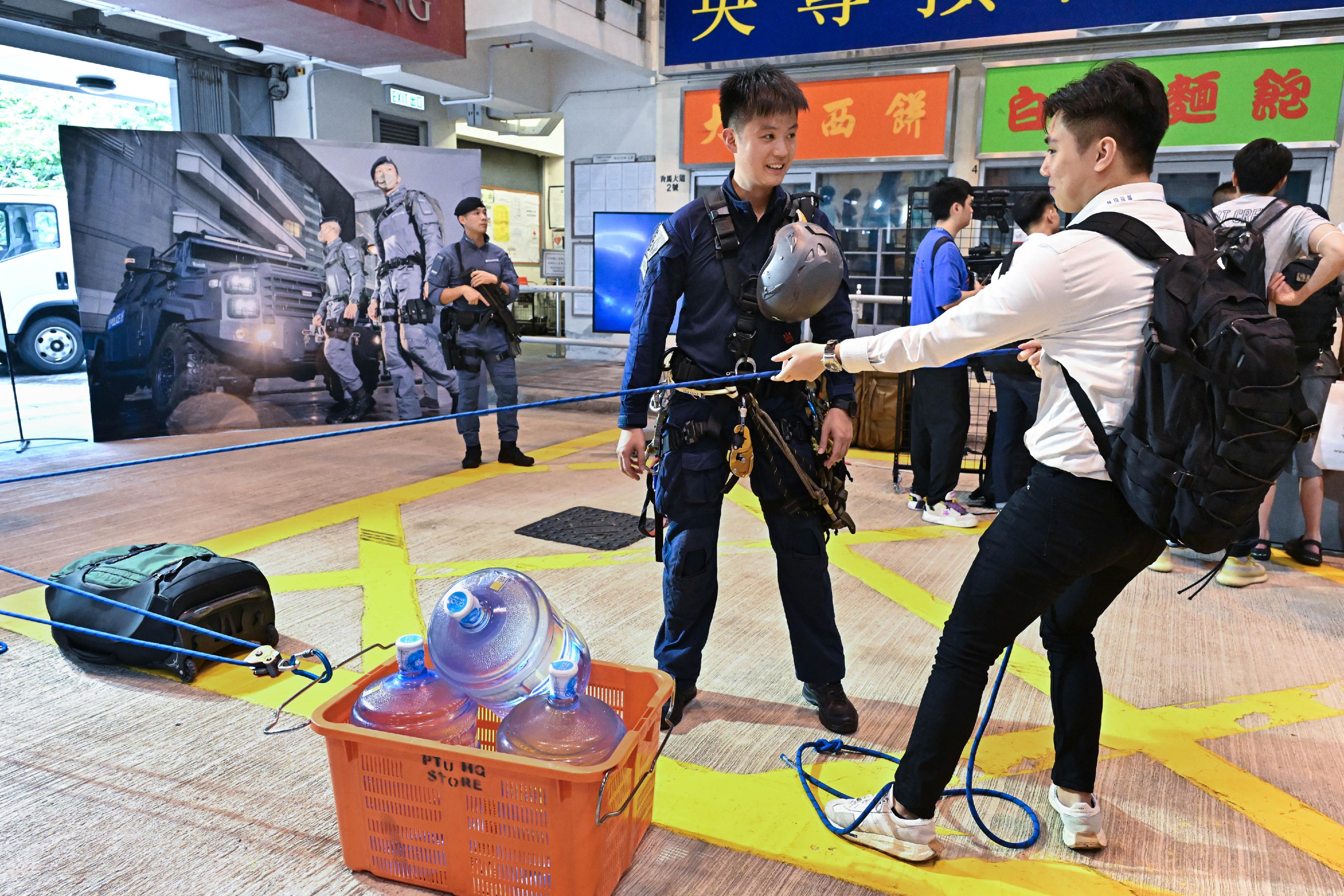 警队今日（六月十六日）在香港警察学院举办「警察招募‧体验日」。图示警察搜查队队员向参加者介绍其工作及装备。