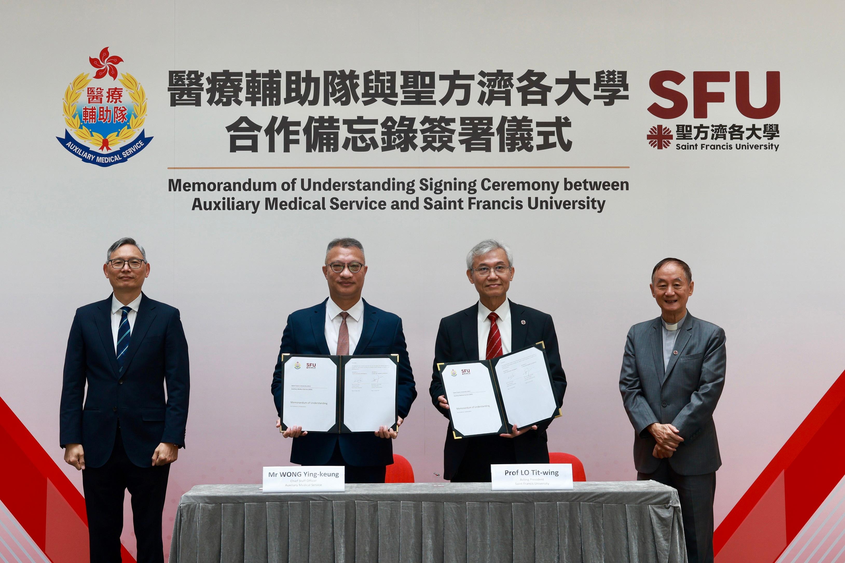 The Auxiliary Medical Service (AMS) and Saint Francis University (SFU) signed a memorandum of understanding (MOU) today (June 22) to officially launch a series of academic collaboration and programmes regarding youth nurturing and development. Witnessed by the Under Secretary for Security, Mr Michael Cheuk (first left), and the Vice-Chairperson of SFU's Council, Reverend Joseph Yim (first right), the MOU was signed by the Chief Staff Officer of the AMS, Mr Wong Ying-keung (second left), and the Acting President of SFU, Professor Lo Tit-wing (second right).