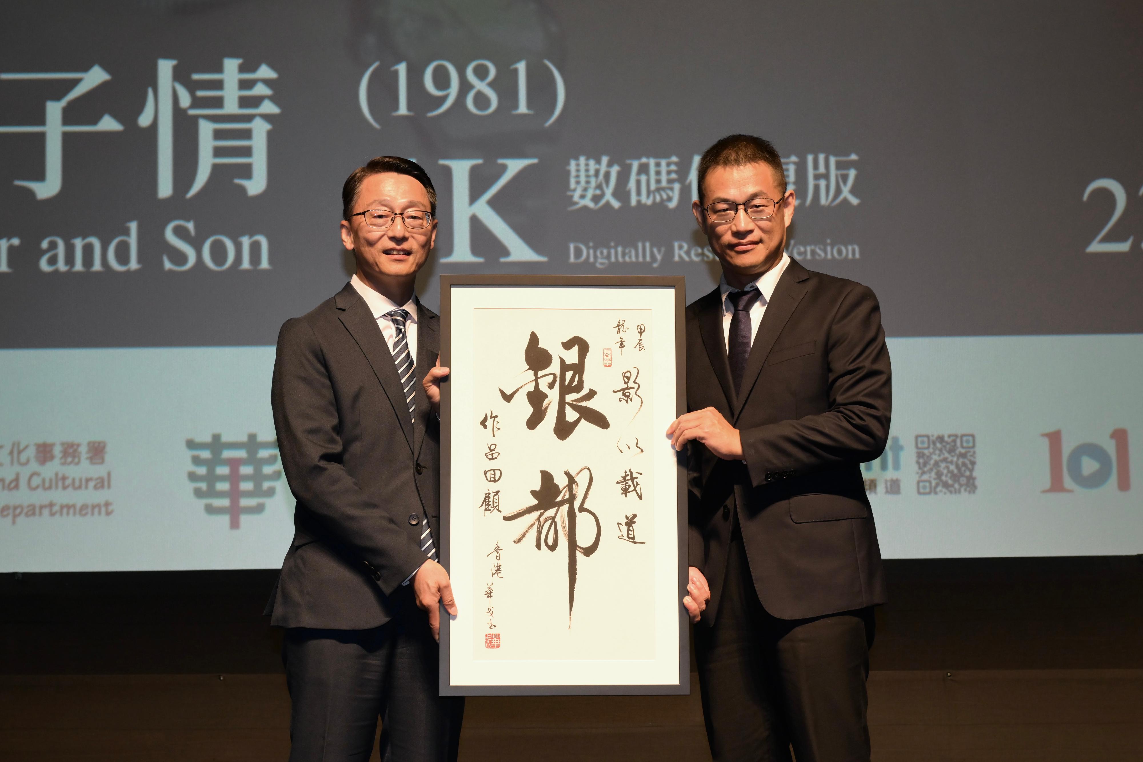 The Hong Kong Film Archive of the Leisure and Cultural Services Department presented the screening of "Father and Son" (1981) (4K Digitally Restored Version) at the Grand Theatre of the Hong Kong Cultural Centre tonight (June 23), marking the opening of the "Integrating Traditional Morality with Modern Reality: Sil-Metropole Retrospective" screening programme, which is one of the programmes of the inaugural Chinese Culture Festival. Photo shows the Director of Leisure and Cultural Services, Mr Vincent Liu (left), presenting a souvenir to the General Manager of Sil-Metropole Organisation Ltd, Mr Ding Kai (right), before the screening.