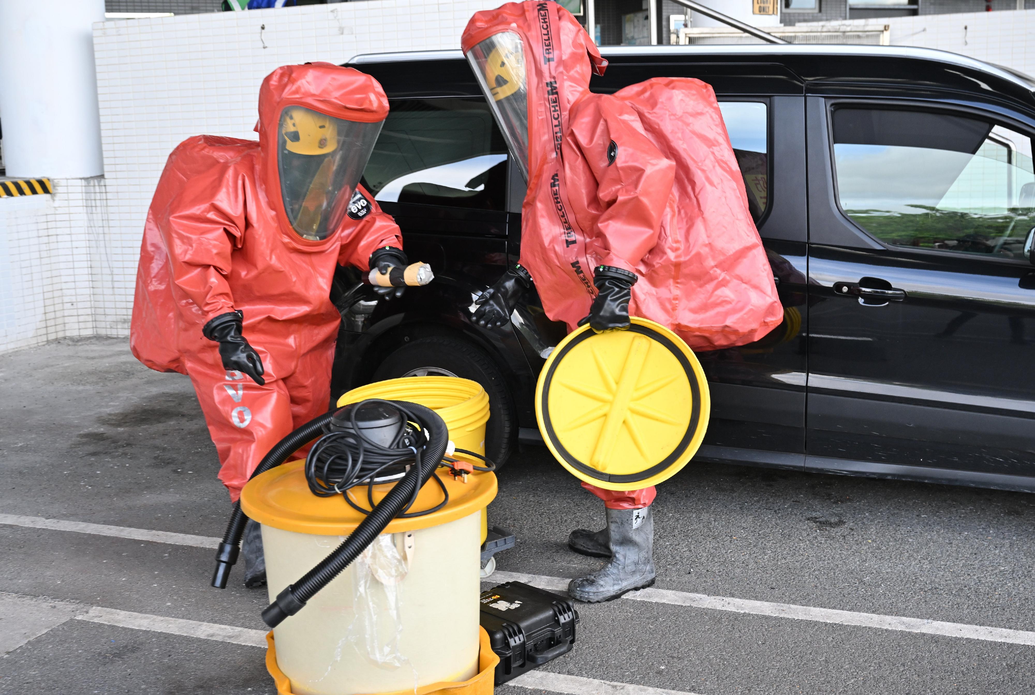 Hong Kong Customs and the Fire Services Department co-organised a counter-terrorism intelligence and hazardous material incident exercise codenamed "WOLFHUNT" this afternoon (June 24) at the Shenzhen Bay Control Point. Photo shows FSD officers wearing chemical protection suits handling hazardous material at the scene.
