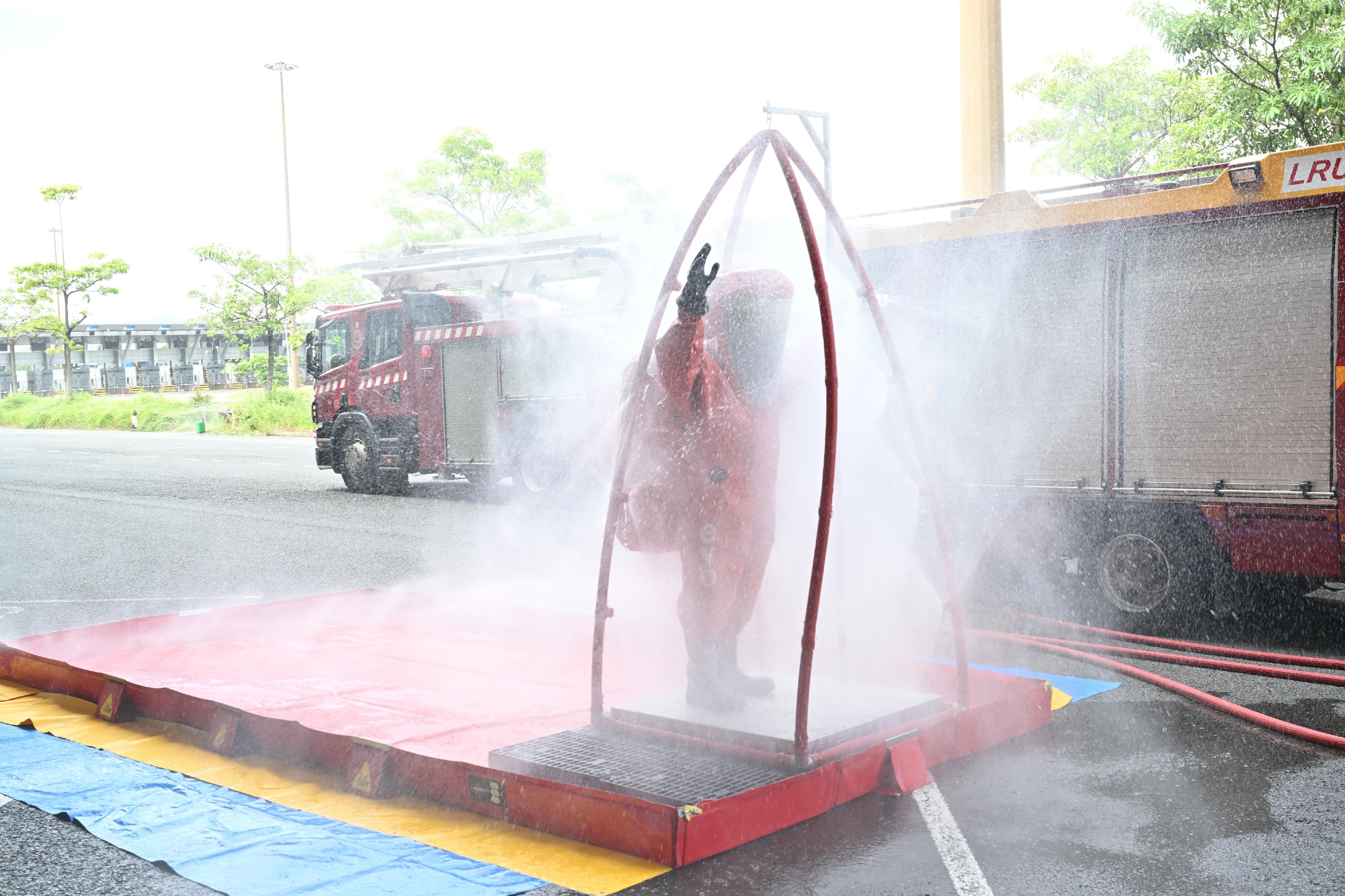 Hong Kong Customs and the Fire Services Department (FSD) co-organised a counter-terrorism intelligence and hazardous material incident exercise codenamed "WOLFHUNT" this afternoon (June 24) at the Shenzhen Bay Control Point. Photo shows an FSD officer conducting a decontamination procedure.

