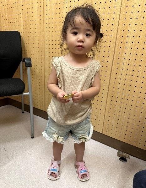 The girl is about two years old. She is about 80 centimetres tall, 10 kilograms in weight and of medium build. She has a round face with yellow complexion and long black hair. She wore a beige vest, light-blue shorts and pink sandals.
