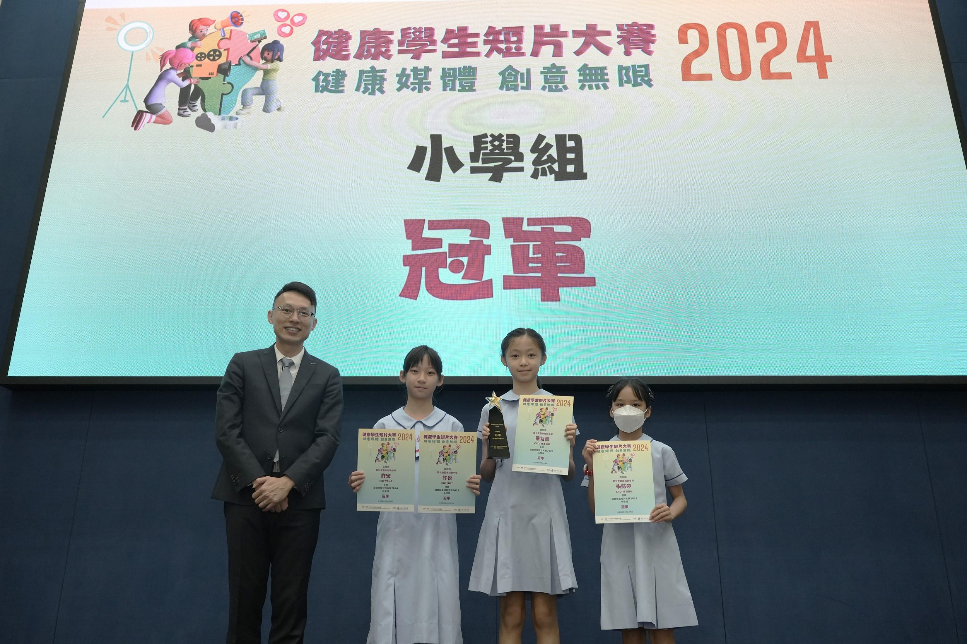 The Office for Film, Newspaper and Article Administration held the "Healthy Student Video Contest 2024" prize presentation ceremony today (June 29). Photo shows the Acting Deputy Director of Film, Newspaper and Article Administration, Mr Chris Fung (first left), with the students of S.K.H. St. Michael's Primary School, the Champion of the Primary School Group.