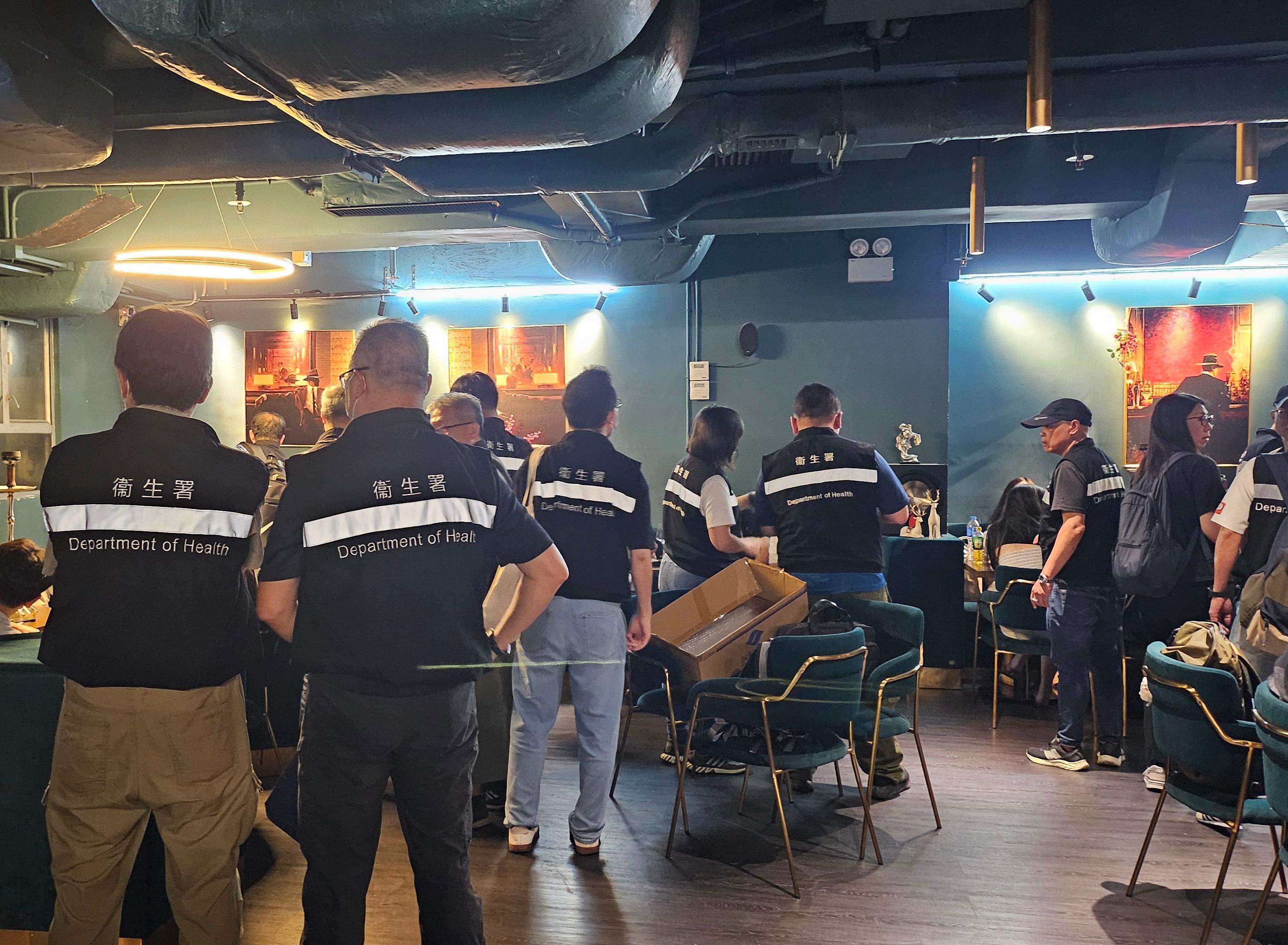 The Tobacco and Alcohol Control Office of the Department of Health yesterday (June 28) evening conducted a large-scale joint operation with the Police against illegal waterpipe smoking activities in no smoking areas in Tsim Sha Tsui, Central and Wan Chai district. Photo shows law enforcement officers taking enforcement action at a bar.