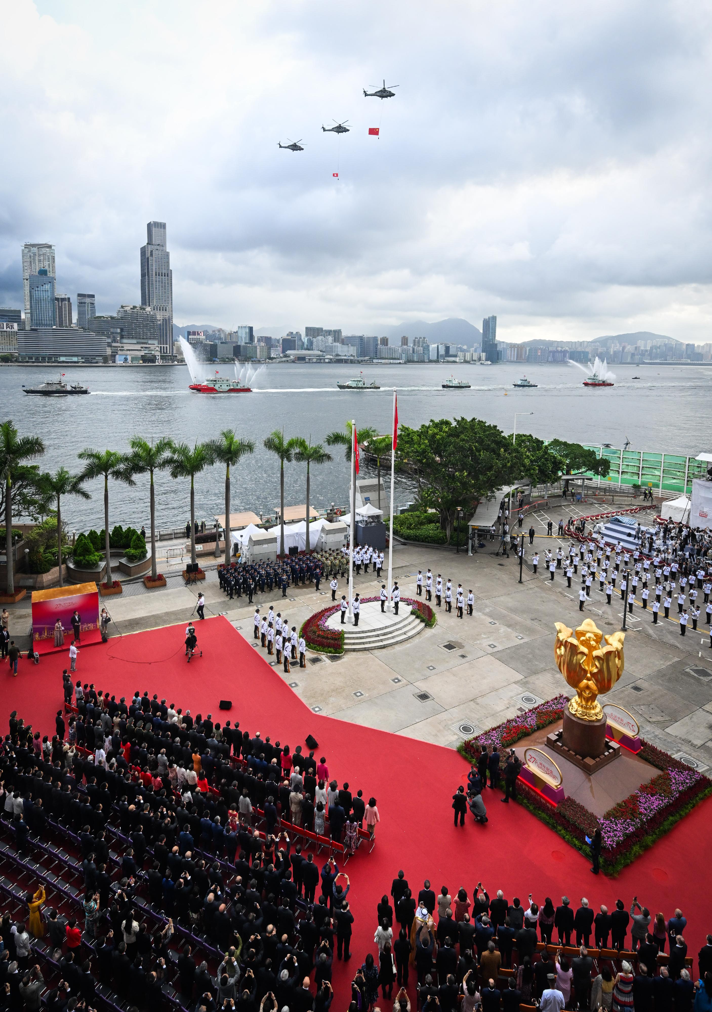 今早（七月一日）在湾仔金紫荆广场举行的香港特别行政区成立二十七周年升旗仪式上，纪律部队和飞行服务队在海上和空中敬礼。