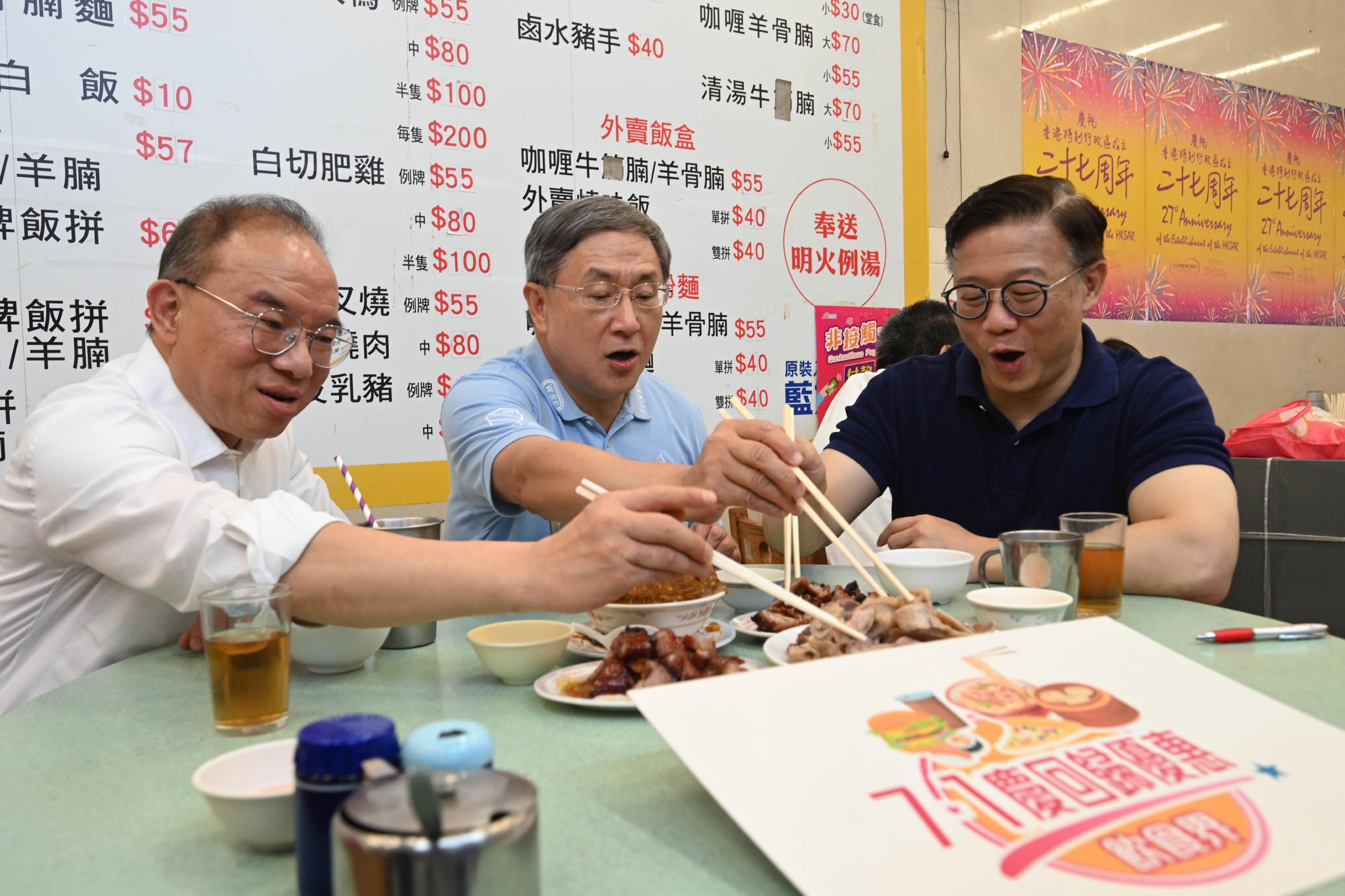 The Acting Chief Secretary for Administration, Mr Cheuk Wing-hing (centre); the Deputy Secretary for Justice, Mr Cheung Kwok-kwan (right); and the Secretary for Constitutional and Mainland Affairs, Mr Erick Tsang Kwok-wai (left), enjoy dining discounts to celebrate Hong Kong's return to the motherland with members of the public at the Wan Chai Bowrington Road Cooked Food Centre today (July 1).