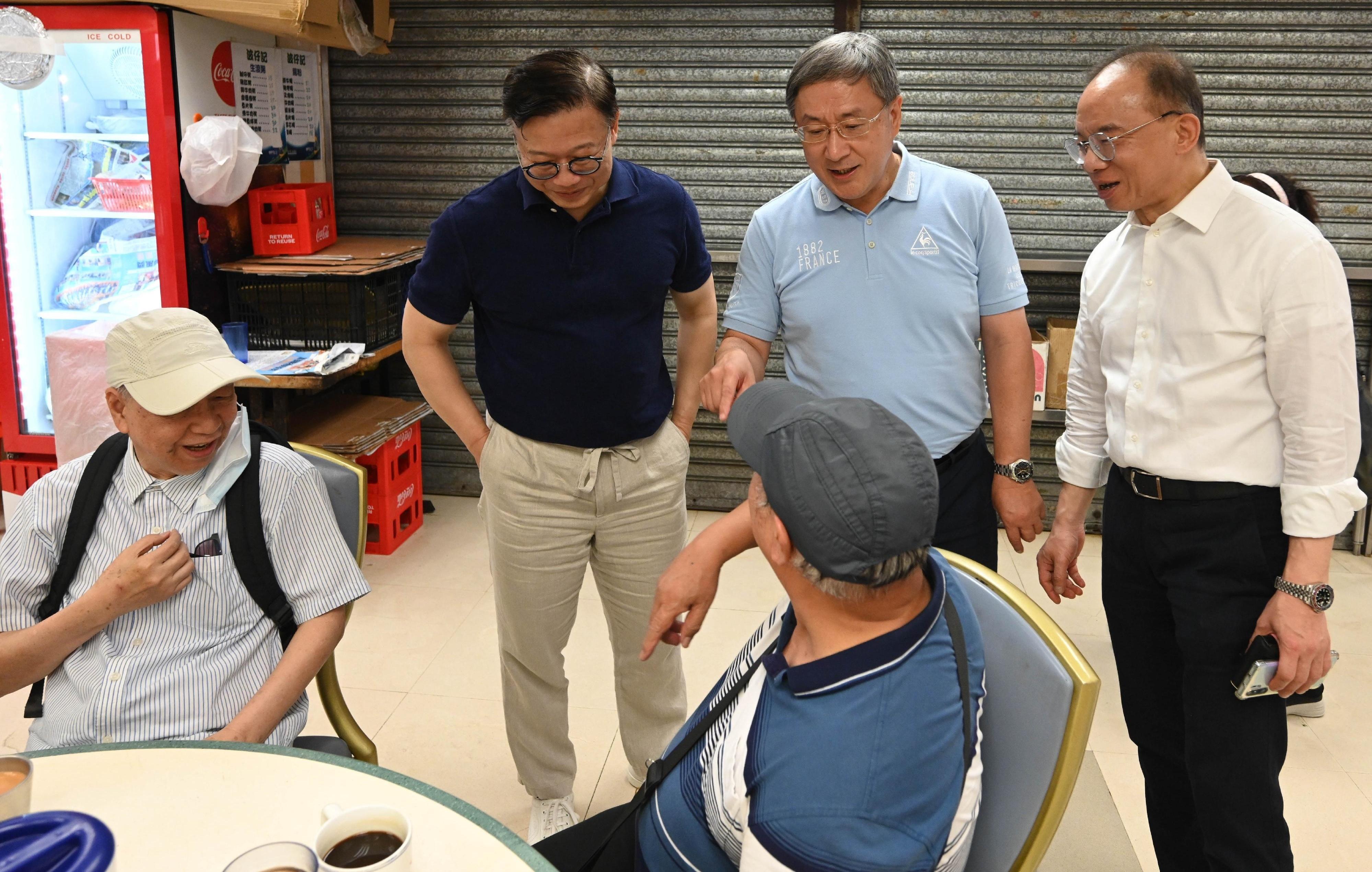 The Acting Chief Secretary for Administration, Mr Cheuk Wing-hing (centre); the Deputy Secretary for Justice, Mr Cheung Kwok-kwan (left); and the Secretary for Constitutional and Mainland Affairs, Mr Erick Tsang Kwok-wai (right), enjoy dining discounts to celebrate Hong Kong's return to the motherland and chat with members of the public at the Wan Chai Bowrington Road Cooked Food Centre today (July 1).