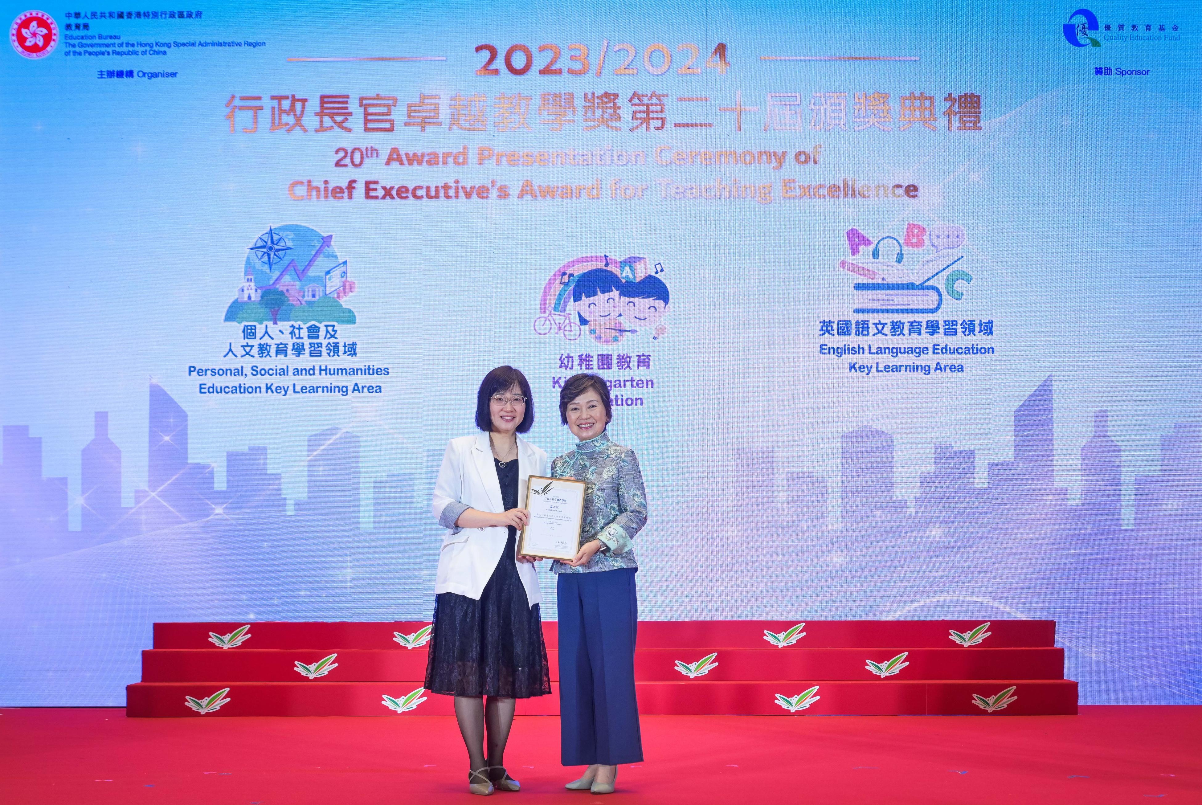 The Secretary for Education, Dr Choi Yuk-lin (right), presents a Certificate of Merit at the Award Presentation Ceremony of the Chief Executive's Award for Teaching Excellence today (July 5).