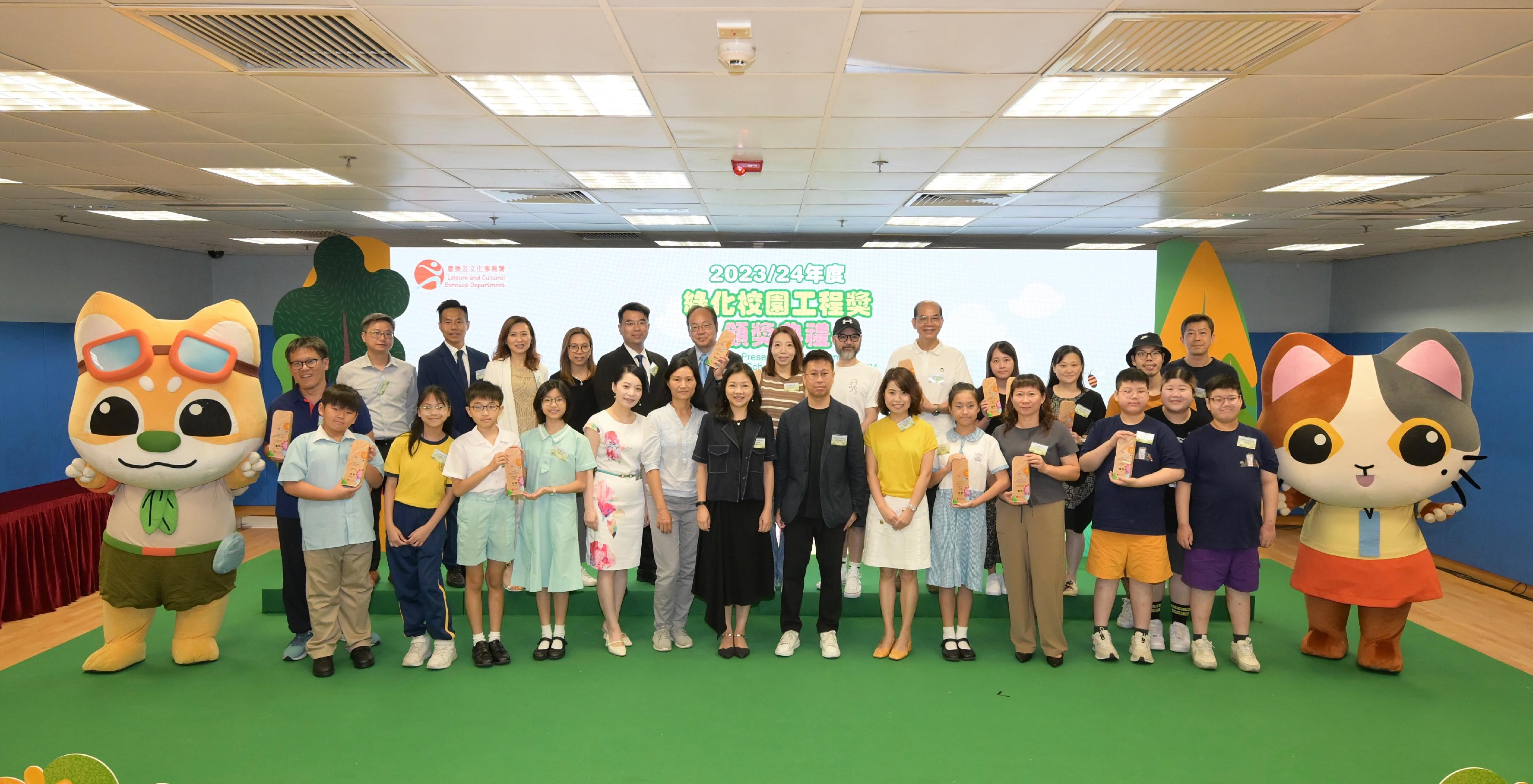 The Leisure and Cultural Services Department held the Greening School Project Award prize presentation ceremony at the Kowloon Park Sports Centre today (July 6) to commend 39 schools for their green school projects and contributions to environmental greening. Photo shows the officiating guests with some winners.