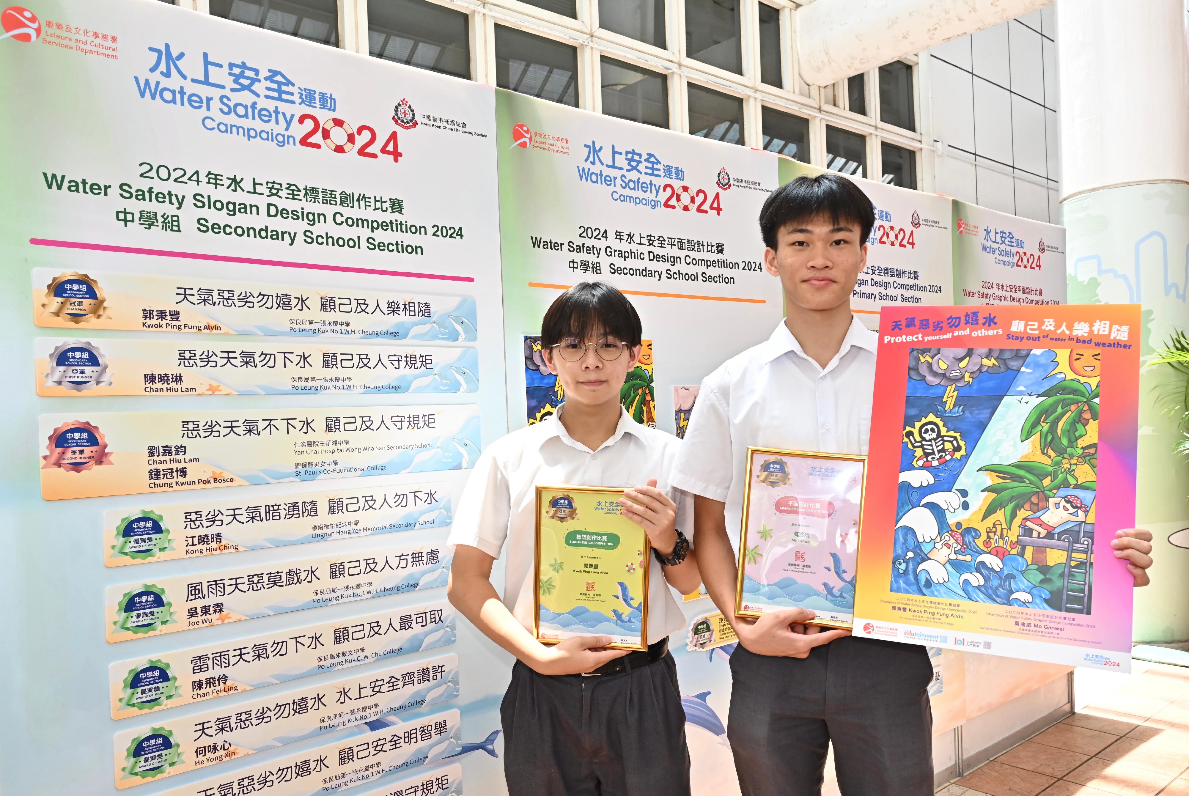 A prize presentation ceremony for the Water Safety Campaign 2024 slogan and graphic design competitions, jointly organised by the Leisure and Cultural Services Department and the Hong Kong China Life Saving Society, was held today (July 6). Pictured with his winning entry is the champion of the secondary school section in the graphic design competition, Mo Ganwei (right), and the champion of the secondary school section in the Chinese slogan competition, Alvin Kwok (left).
