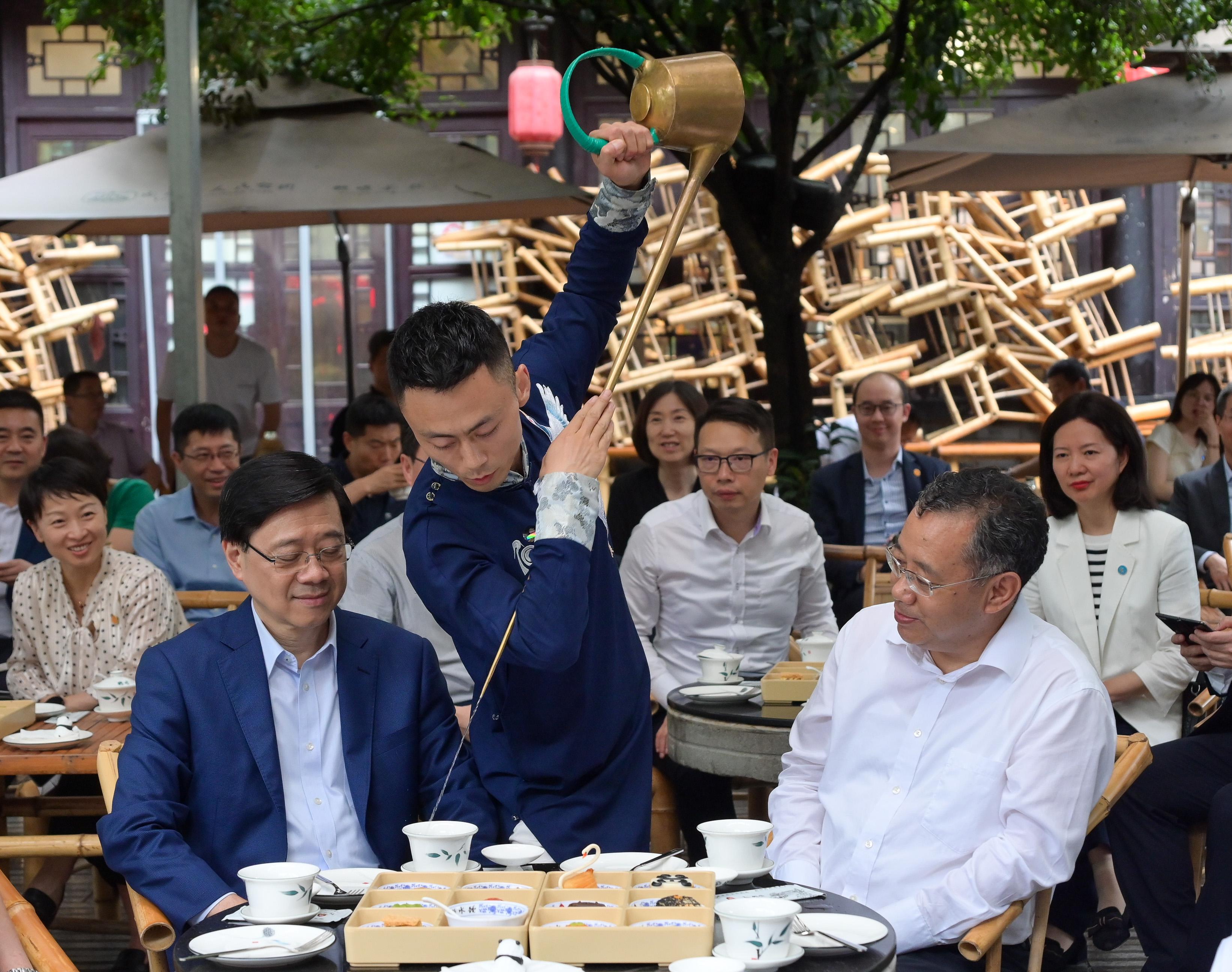 行政长官李家超今日（七月九日）继续在四川的访问行程。图示李家超（左）在四川省委常委、副省长普布顿珠（右）陪同下到访成都市人民公园了解当地饮食文化。