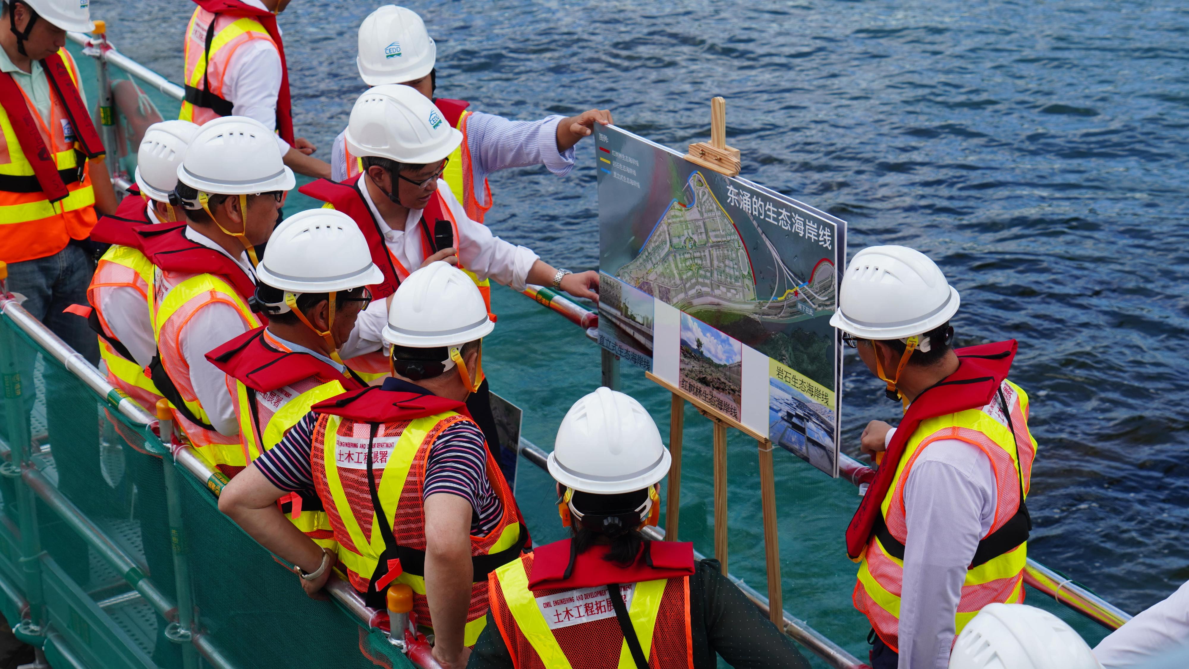 The Development Bureau, the Civil Engineering and Development Department and the Planning Department today (July 11) held an expert meeting to exchange views with a delegation of top environmental and ecological experts from the Mainland on the environmental impact assessment for the proposed reclamation works of the Kau Yi Chau Artificial Islands. Photo shows the delegation learning about the achievements of the reclamation project in Tung Chung this morning.