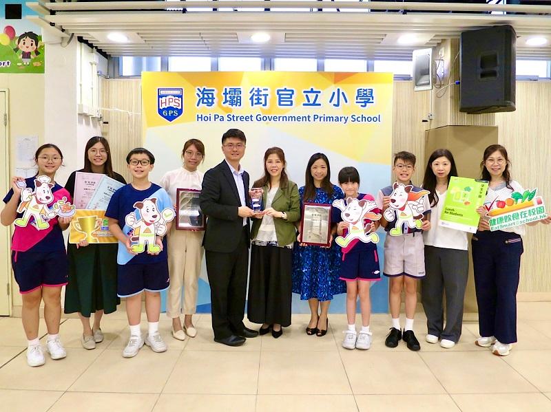 Representatives of the Department of Health (DH) visited schools attaining accreditation of the EatSmart School Accreditation Scheme in the 2023/24 school year and presented awards in June. Photo shows the Head of Health Promotion Branch (HPB) of the DH, Dr Leung Yiu-hong (fifth left), along with other HPB representatives presenting the Award for Continuous Promotion of Healthy Eating at School to the Hoi Pa Street Government Primary School, which attained the EatSmart School accreditation for the fifth consecutive time, during a school visit.