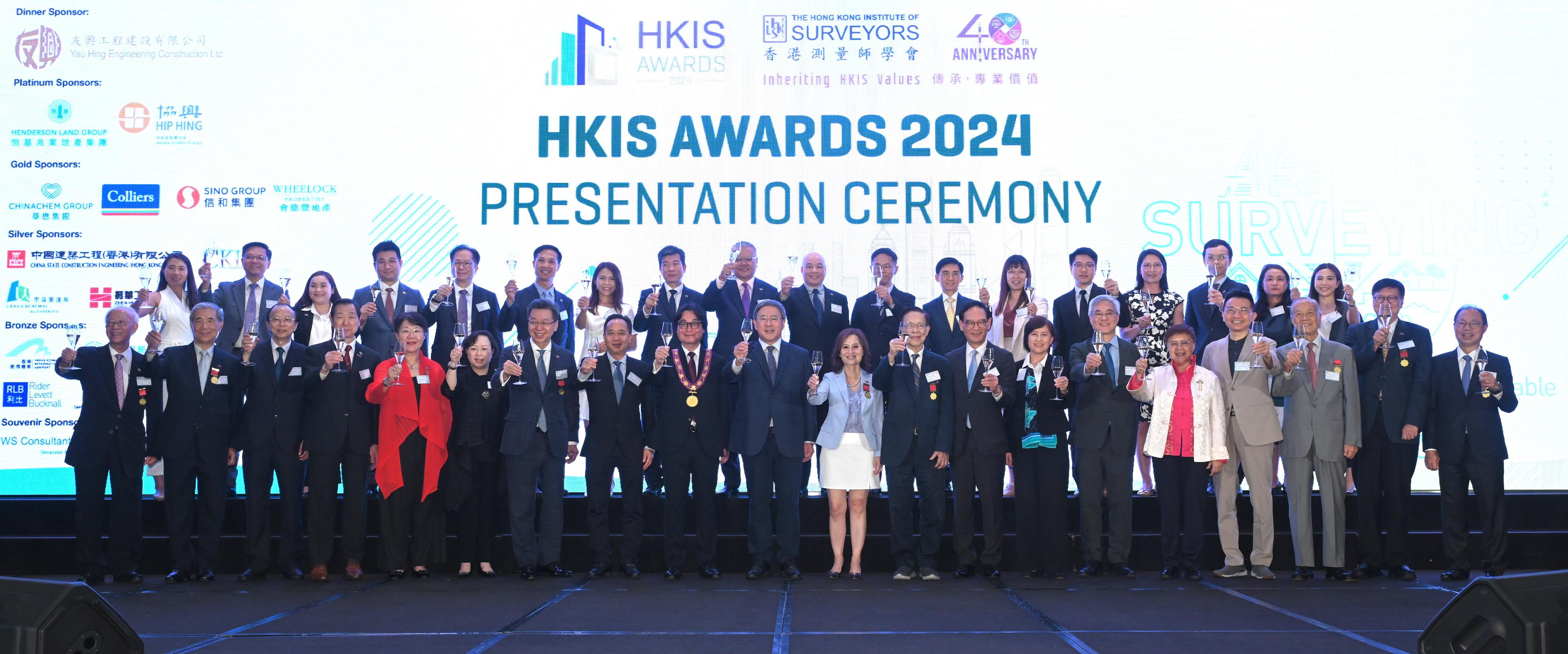 The Deputy Chief Secretary for Administration, Mr Cheuk Wing-hing (first row, tenth left), joins the President of the Hong Kong Institute of Surveyors (HKIS), Mr Francis Lam (first row, ninth left), and the Chairlady of the HKIS Awards 2024 Organising Committee, Professor Winnie Shiu (first row, eleventh left), to propose a toast at the Hong Kong Institute of Surveyors (HKIS) Awards 2024 Presentation Ceremony this evening (July 12).