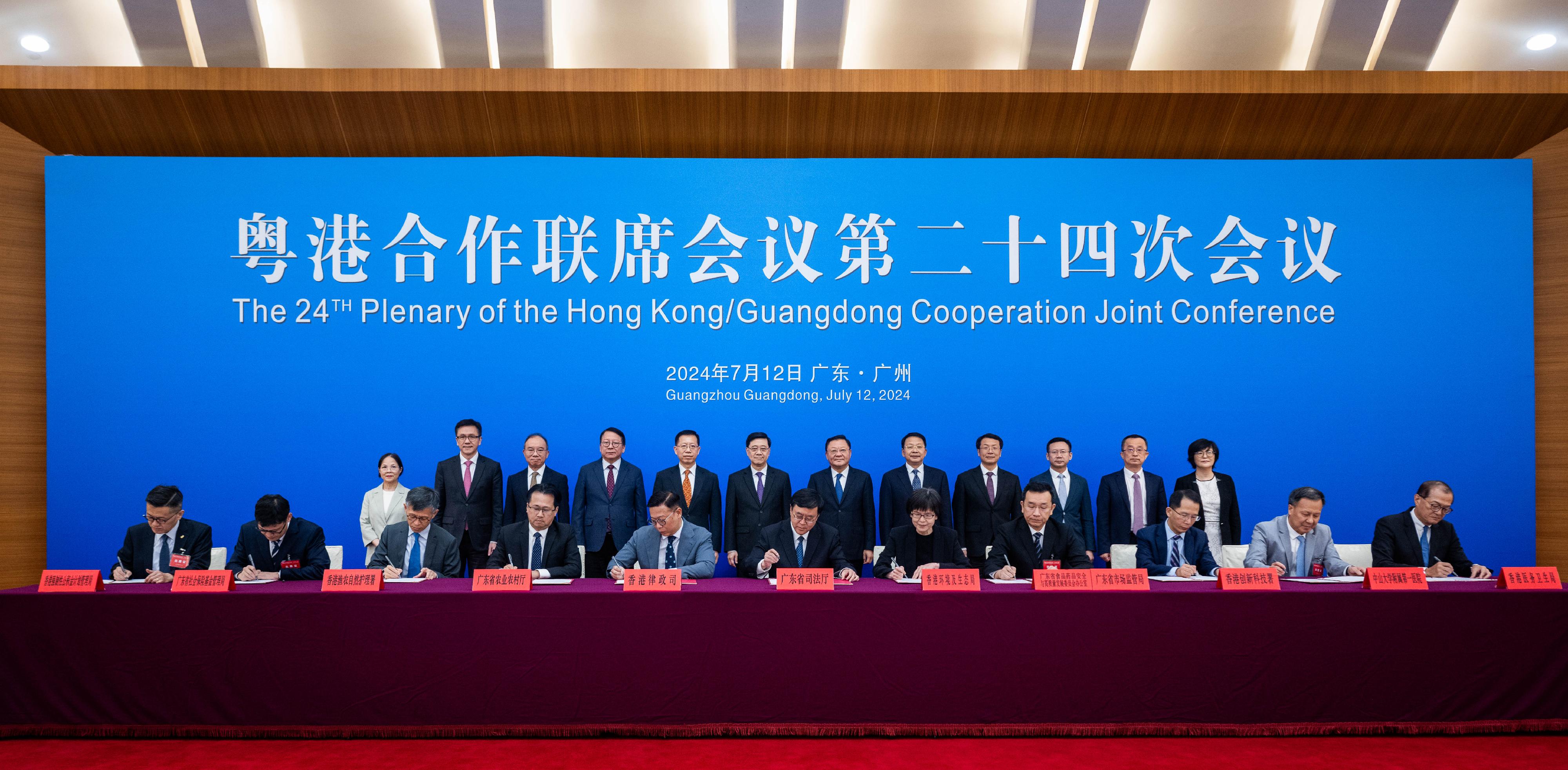 The Chief Executive, Mr John Lee, led a HKSAR Government delegation to attend the 24th Plenary of the Hong Kong/Guangdong Co-operation Joint Conference in Guangzhou today (July 12). Photo shows (back row, from 4th left) the Chief Secretary for Administration, Mr Chan Kwok-ki; Member of the Office Leadership of the Hong Kong and Macao Affairs Office of the State Council Mr Xiang Bin; Mr Lee; the Governor of Guangdong Province, Mr Wang Weizhong; Deputy Director of the Liaison Office of the Central People's Government in the HKSAR Mr Yin Zonghua, and other officials from both sides witnessing the signing of agreements on co-operation between Hong Kong and Guangdong. The agreements signed include the Arrangement on Exchanges and Co-operation between the Department of Justice of Guangdong Province and the Department of Justice of the Government of the HKSAR; the Co-operation Agreement between Guangdong and Hong Kong on the Work on Quality, Testing and Certification; Agreement on Exchanges and Co-operation in Food Safety for Hong Kong/Guangdong; the Memorandum of Understanding on Facilitation of Technological Exchange and Co-operation on Sustainable Development of Agriculture; the Memorandum of Understanding for Co-operation on Exemption of Hong Kong Residents from Participation in Basic Pension Insurance; and the Memorandum of Understanding between the Health Bureau of the Government of the HKSAR and the First Affiliated Hospital, Sun Yat-sen University on Elderly Health Care Voucher Greater Bay Area Pilot Scheme and Related Policy Studies.