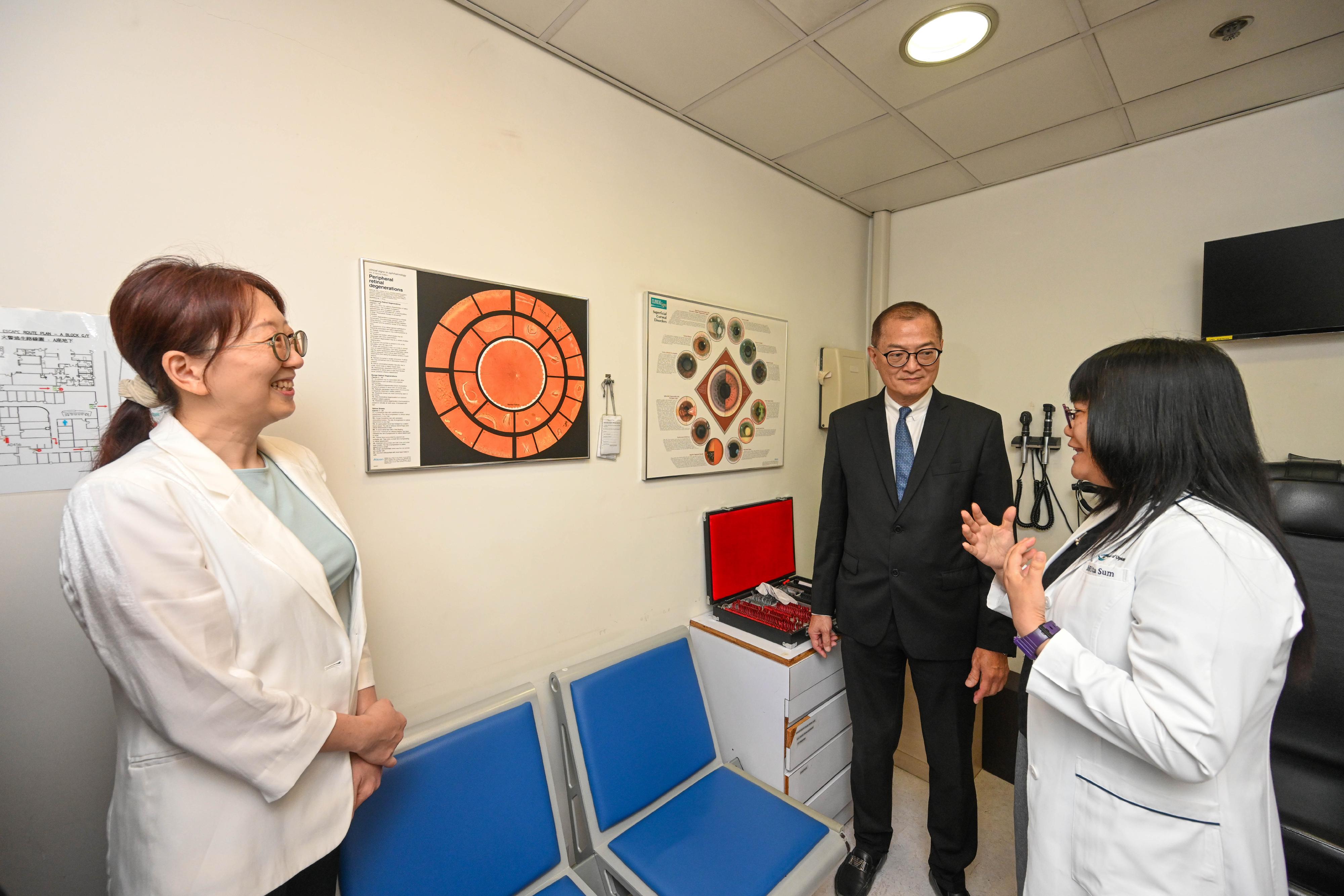 The Secretary for Health, Professor Lo Chung-mau (centre), visits the facilities and chats with staff and students of the School of Optometry at the Hong Kong Polytechnic University today (July 22).