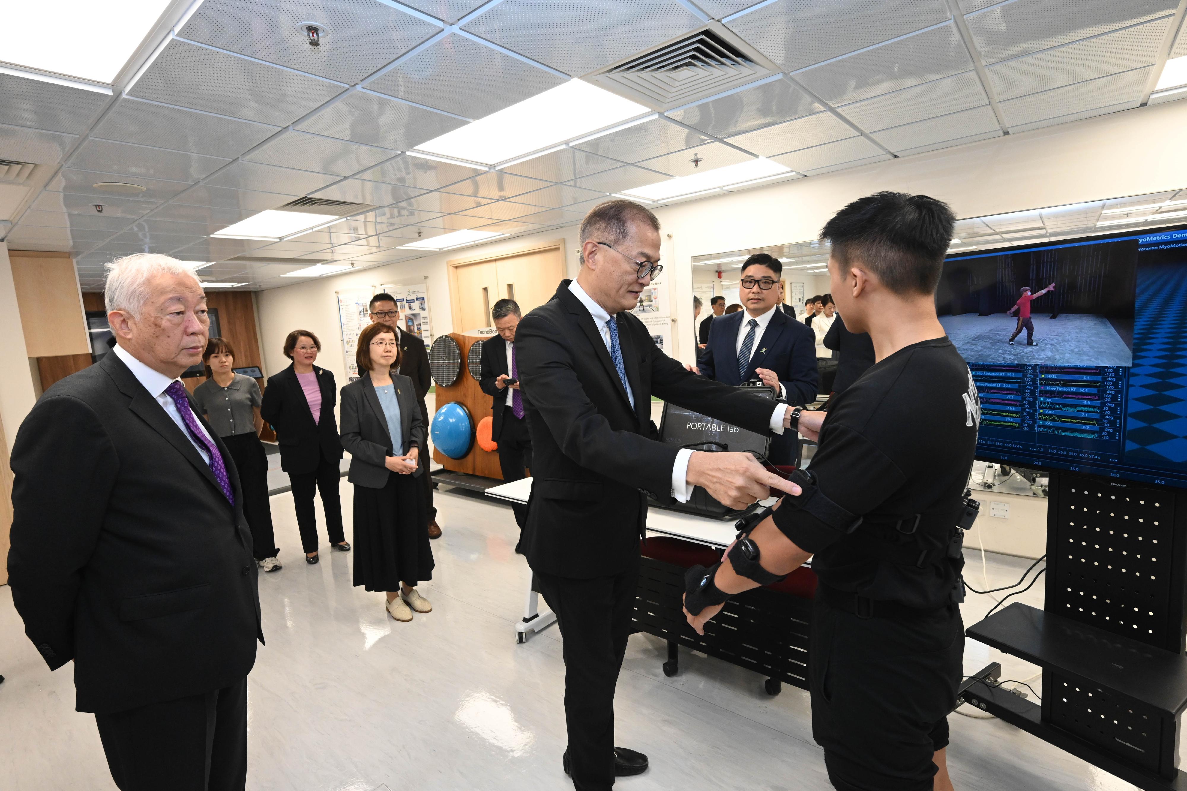 The Secretary for Health, Professor Lo Chung-mau (centre), visits the teaching facilities of the Department of Rehabilitation Sciences at the Hong Kong Polytechnic University (PolyU) today (July 22). Looking on is the Deputy Chairman of PolyU Council, Dr Lawrence Li (first left).