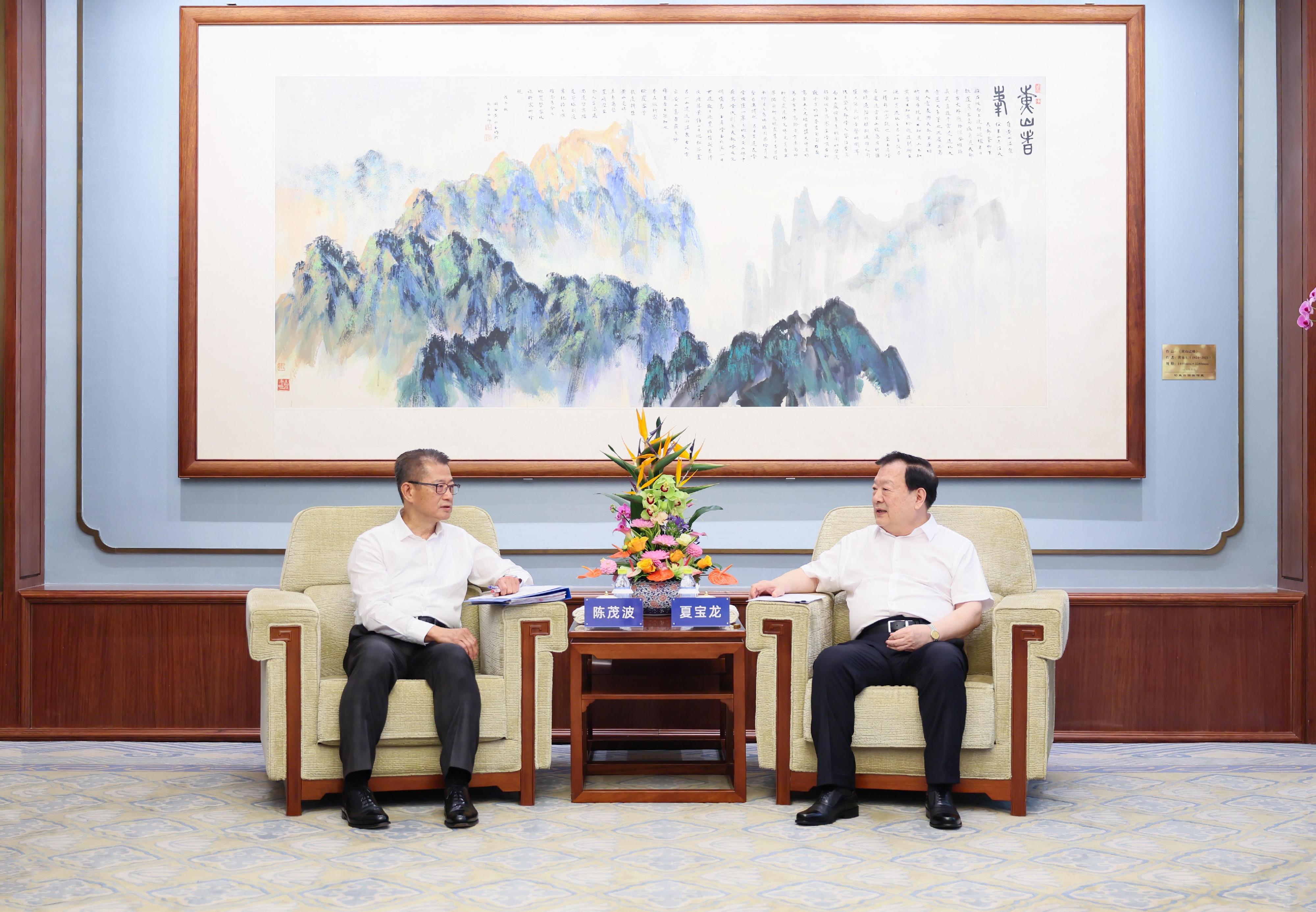 The Financial Secretary, Mr Paul Chan, began his visit programme to Beijing today (July 23). Photo shows the Director of the Hong Kong and Macao Affairs Office of the State Council, Mr Xia Baolong (right), meeting with Mr Chan (left). The Secretary for Financial Services and the Treasury, Mr Christopher Hui; the Chief Executive of the Hong Kong Monetary Authority, Mr Eddie Yue; the Chief Executive Officer of the Insurance Authority, Mr Clement Cheung; and the Acting Chief Executive Officer of the Securities and Futures Commission, Ms Christina Choi, also joined the meeting.