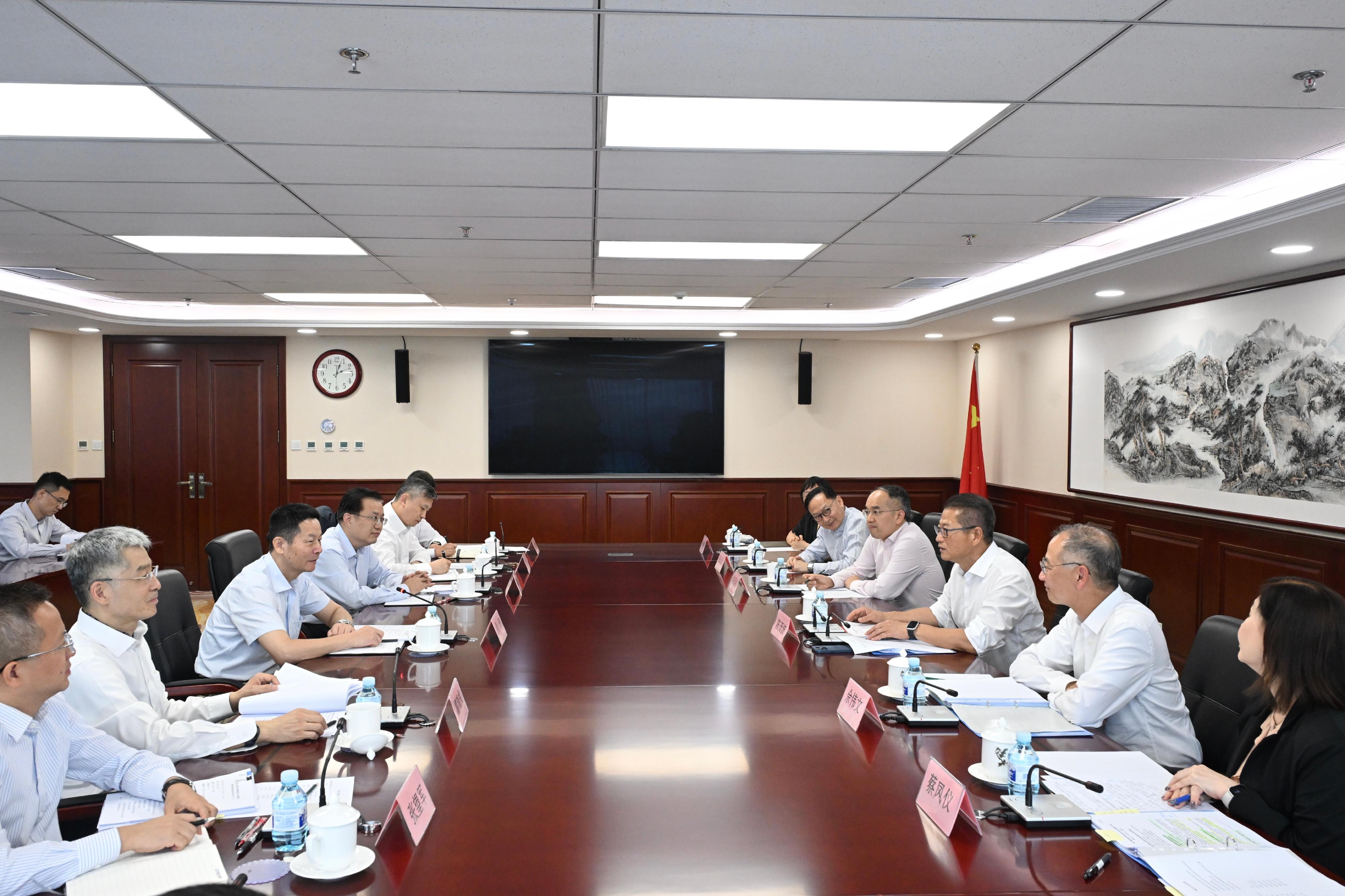 The Financial Secretary, Mr Paul Chan, continued his visit to Beijing today (July 24). Photo shows Mr Chan (third right) meeting with the Chairman of the China Securities Regulatory Commission, Mr Wu Qing (third left). The Secretary for Financial Services and the Treasury, Mr Christopher Hui (fourth right); the Chief Executive of the Hong Kong Monetary Authority, Mr Eddie Yue (second right); the Chief Executive Officer of the Insurance Authority, Mr Clement Cheung (fifth right); and the Acting Chief Executive Officer of the Securities and Futures Commission, Ms Christina Choi (first right), also attended the meeting.