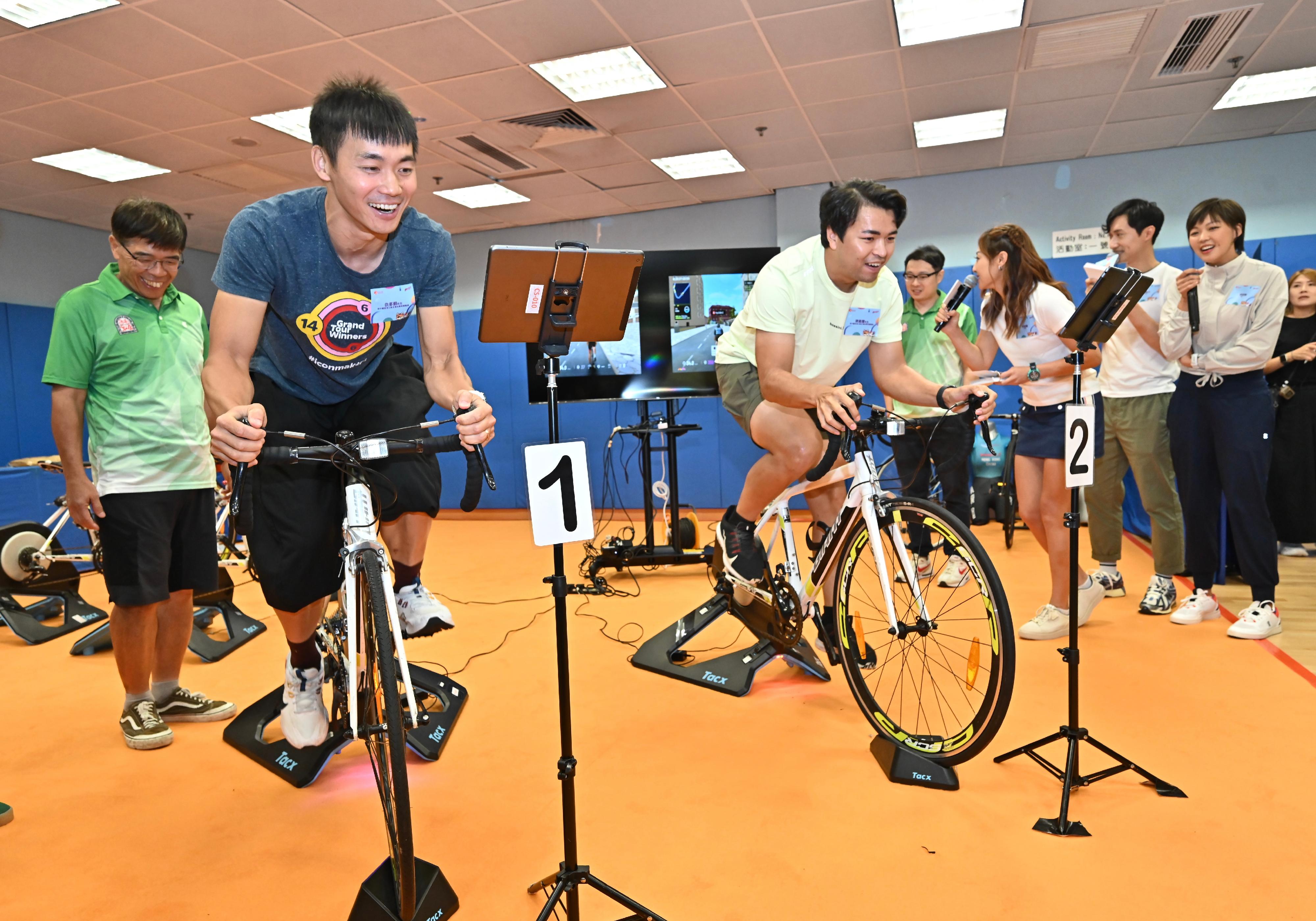 The Launching Ceremony of the Olympics Focal Site was held at the Secondary Hall of the Kowloon Park Sports Centre today (July 26). Photo shows former members of the Hong Kong Cycling Team Leung Ka-yu (right) and Domino Chau (left) showcasing their cycling skills to the audience.