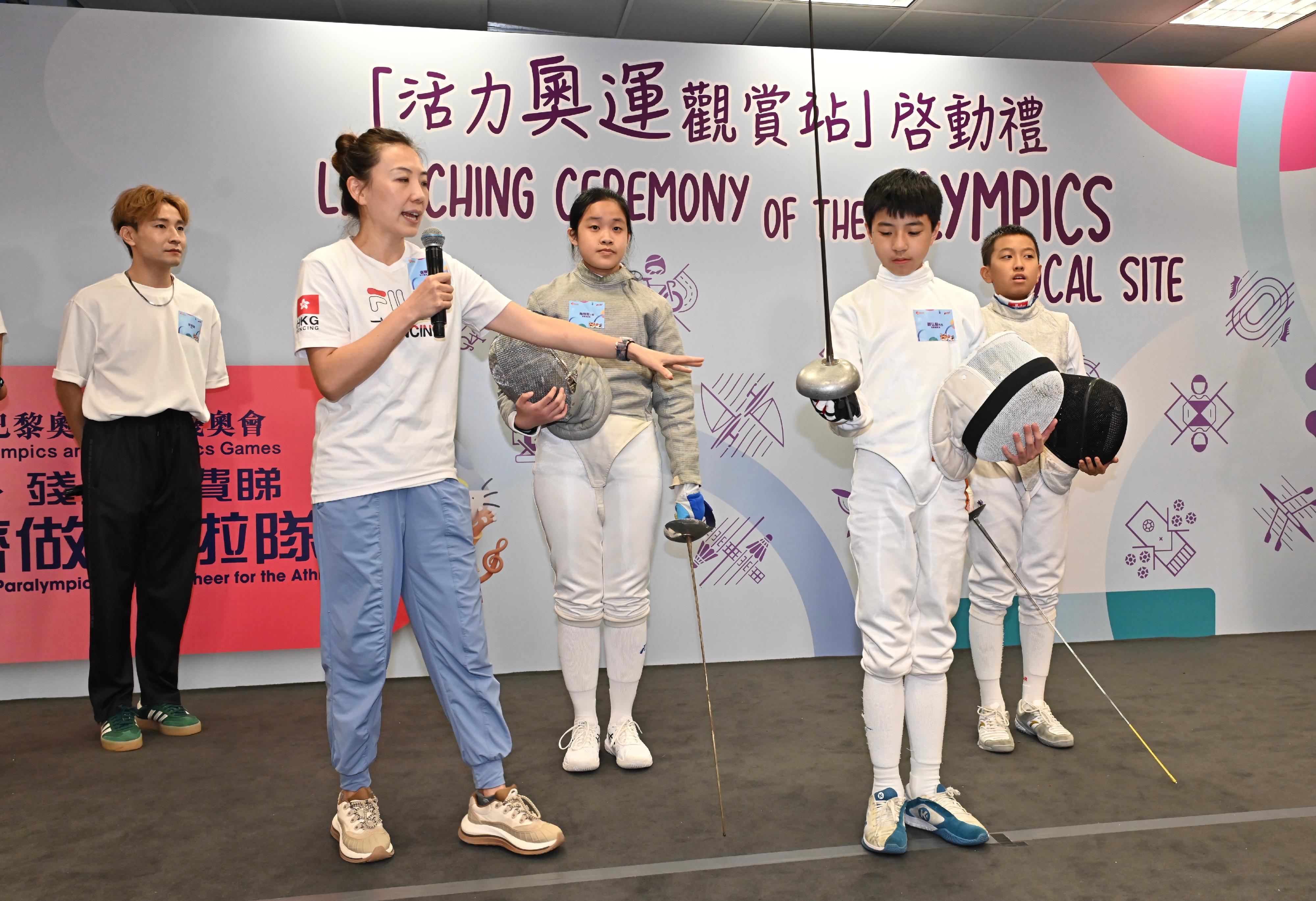 The Launching Ceremony of the Olympics Focal Site was held at the Secondary Hall of the Kowloon Park Sports Centre today (July 26). Photo shows former member of the Hong Kong Fencing Team Lo Shan-shan (second left) and students participating in a fencing activity.