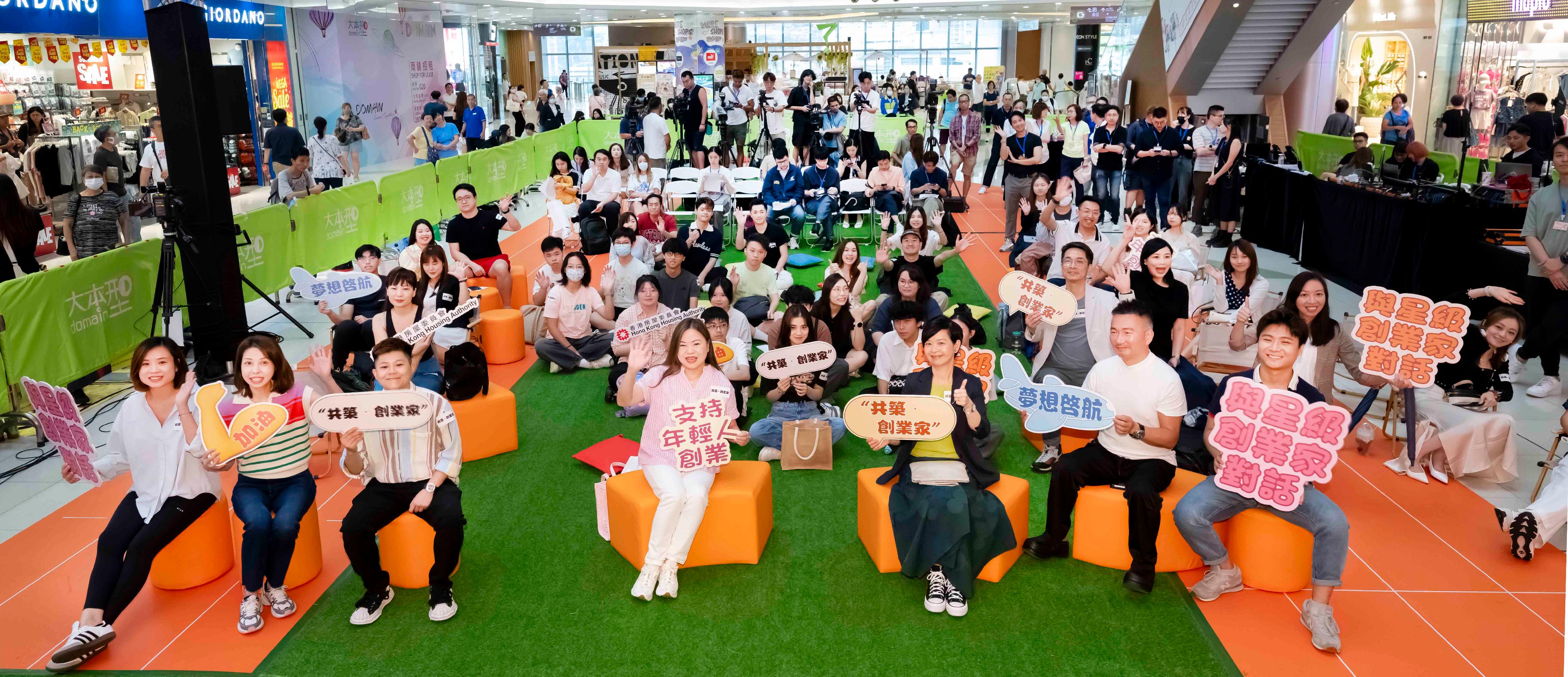 为鼓励和支持青年实践创业梦想，香港房屋委员会（房委会）推出「共筑・创业家」计划，在旗下商场向青年免租金提供商铺，让他们试行创业计划。图示房屋局局长兼房委会主席何永贤（前排左五）、房屋局常任秘书长兼房屋署署长罗淑佩（前排左四），以及其他嘉宾在活动上合照。