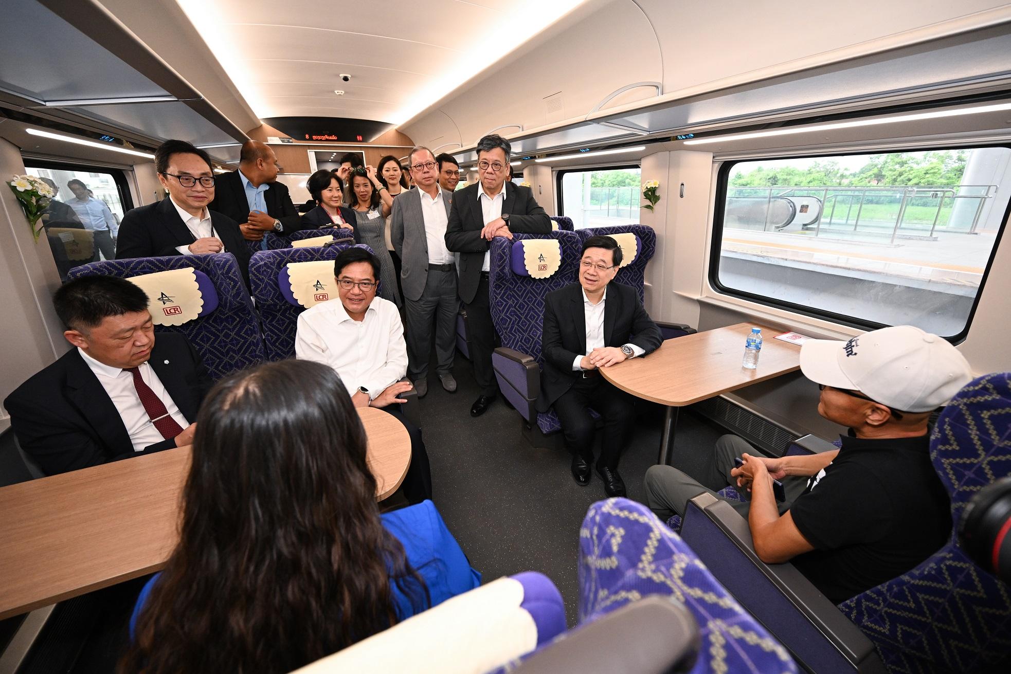 The Chief Executive, Mr John Lee, today (July 29) led a Hong Kong Special Administrative Region delegation to continue their visit in Vientiane, the capital of Laos. Photo shows Mr Lee (front row, first right); the Deputy Financial Secretary, Mr Michael Wong (front row, second right); the Secretary for Commerce and Economic Development, Mr Algernon Yau (back row, first right), and the delegation members chatting with the passengers in the car compartment at the Vientiane Station of the China-Laos Railway.