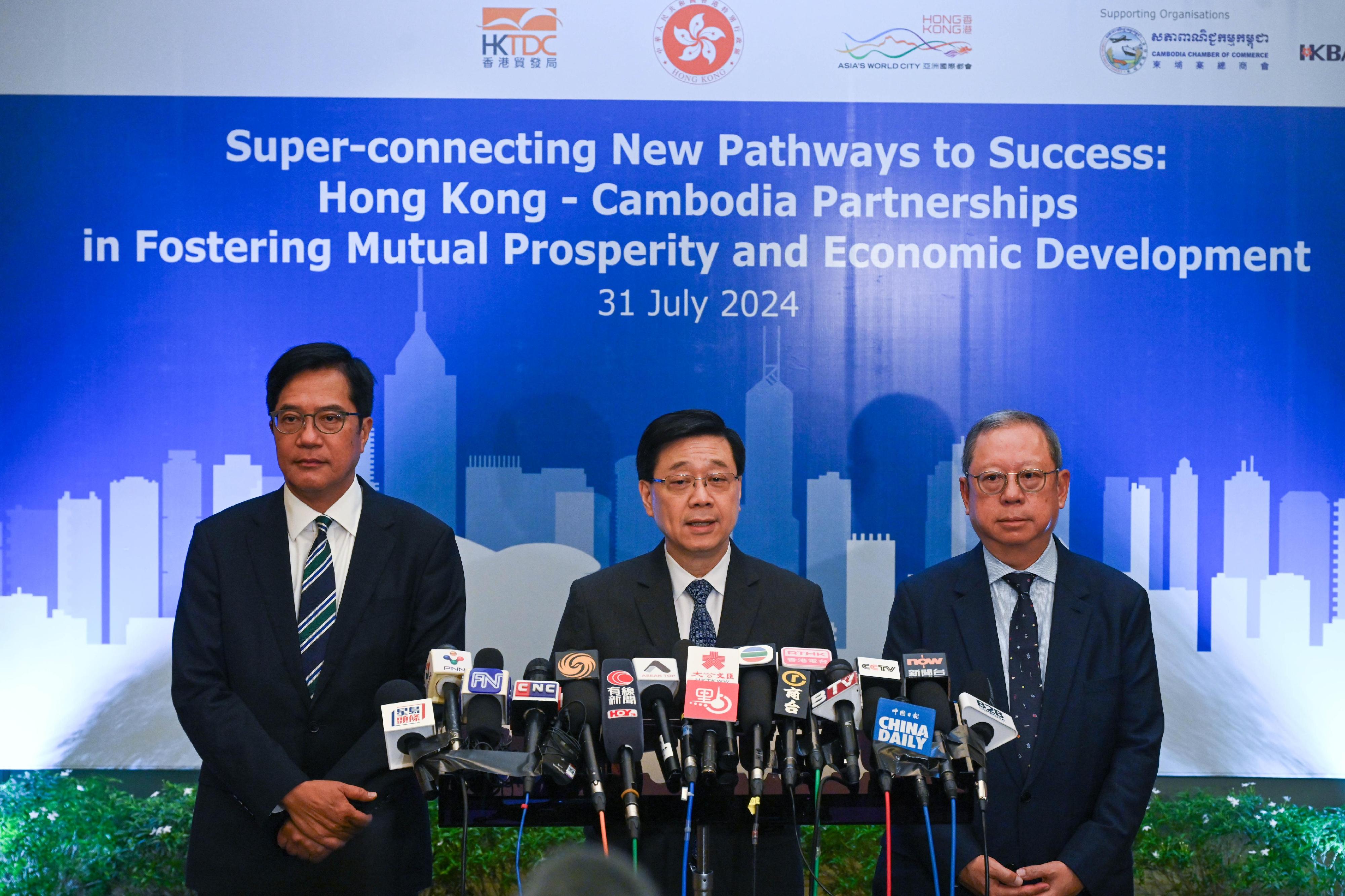 The Chief Executive, Mr John Lee (centre), together with the Deputy Financial Secretary, Mr Michael Wong (left), and the Chairman of the Hong Kong Trade Development Council, Dr Peter Lam (right), meets the media in Cambodia today (July 31).