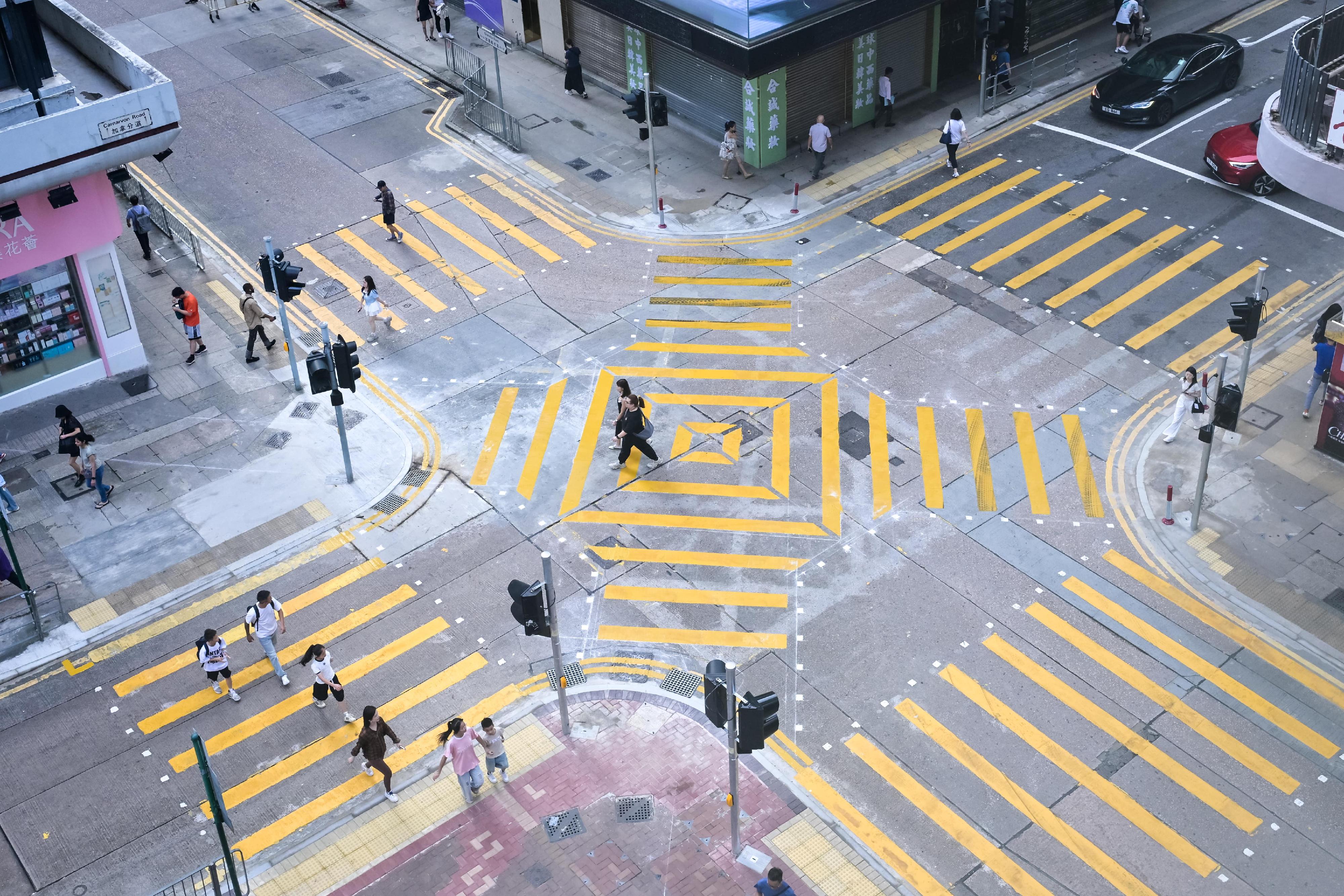 The Transport Department announced that the diagonal crossings at the junction of Carnarvon Road and Granville Road in Tsim Sha Tsui are open for use today (August 2). This is the second trial location under the trial scheme for diagonal crossings following the one at the junction of Sha Kok Street and Yat Tai Street in Sha Tin, giving pedestrians the option to take a diagonal route to cross the road directly to the footpath on the other side, shortening the walking distance and time required.