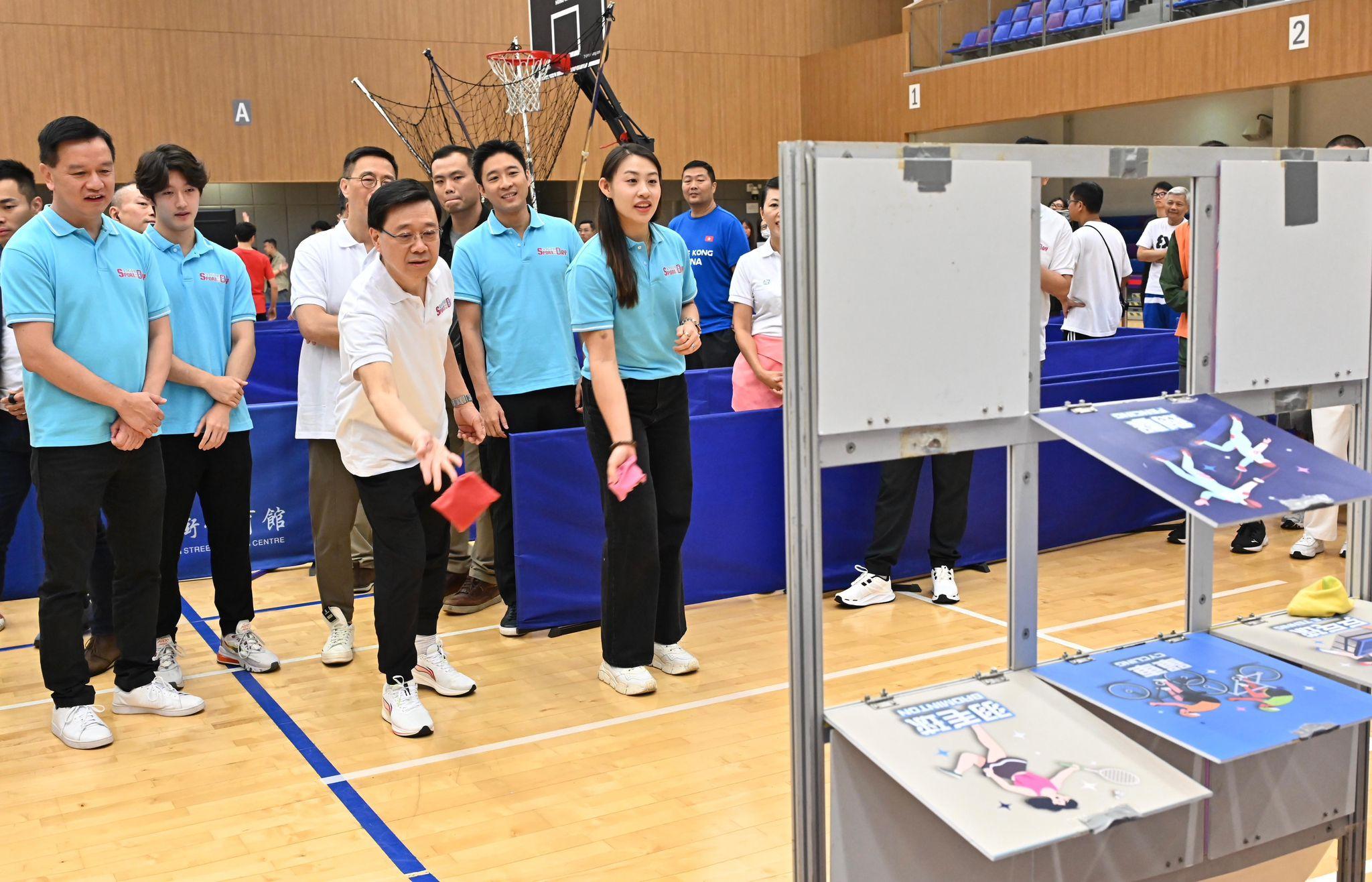 李家超（右二）和劍擊運動員佘繕妡（右一）參與由中國香港體育協會暨奧林匹克委員會舉辦體育節活動攤位遊戲。