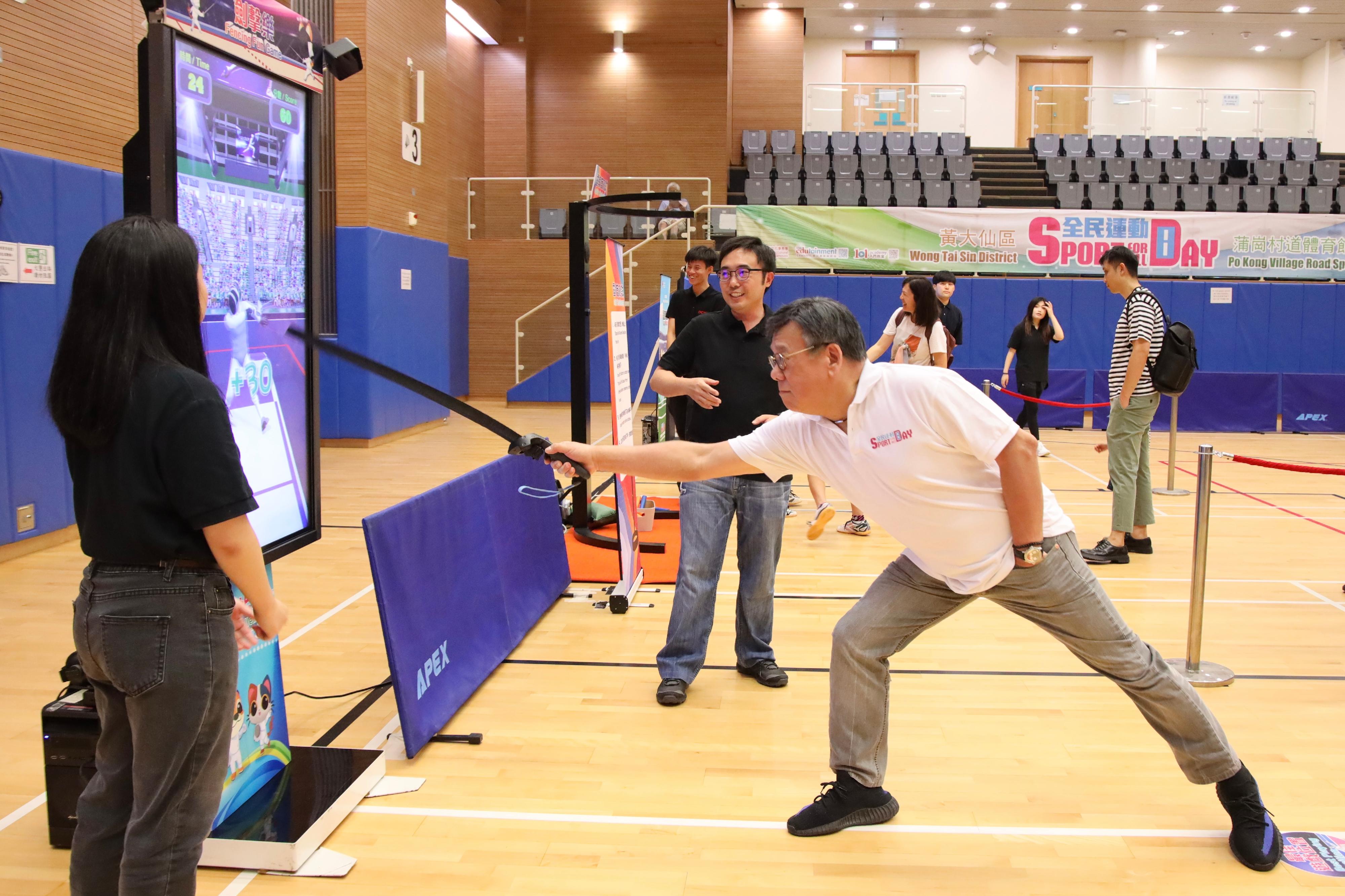 The Secretary for Commerce and Economic Development, Mr Algernon Yau, participated in the Sport For All Day 2024 activities organised by the Leisure and Cultural Services Department at the Po Kong Village Road Sports Centre today (August 4) to encourage the public to engage in regular sports and physical activities. Photo shows Mr Yau (right) taking part in a fencing experience session.
