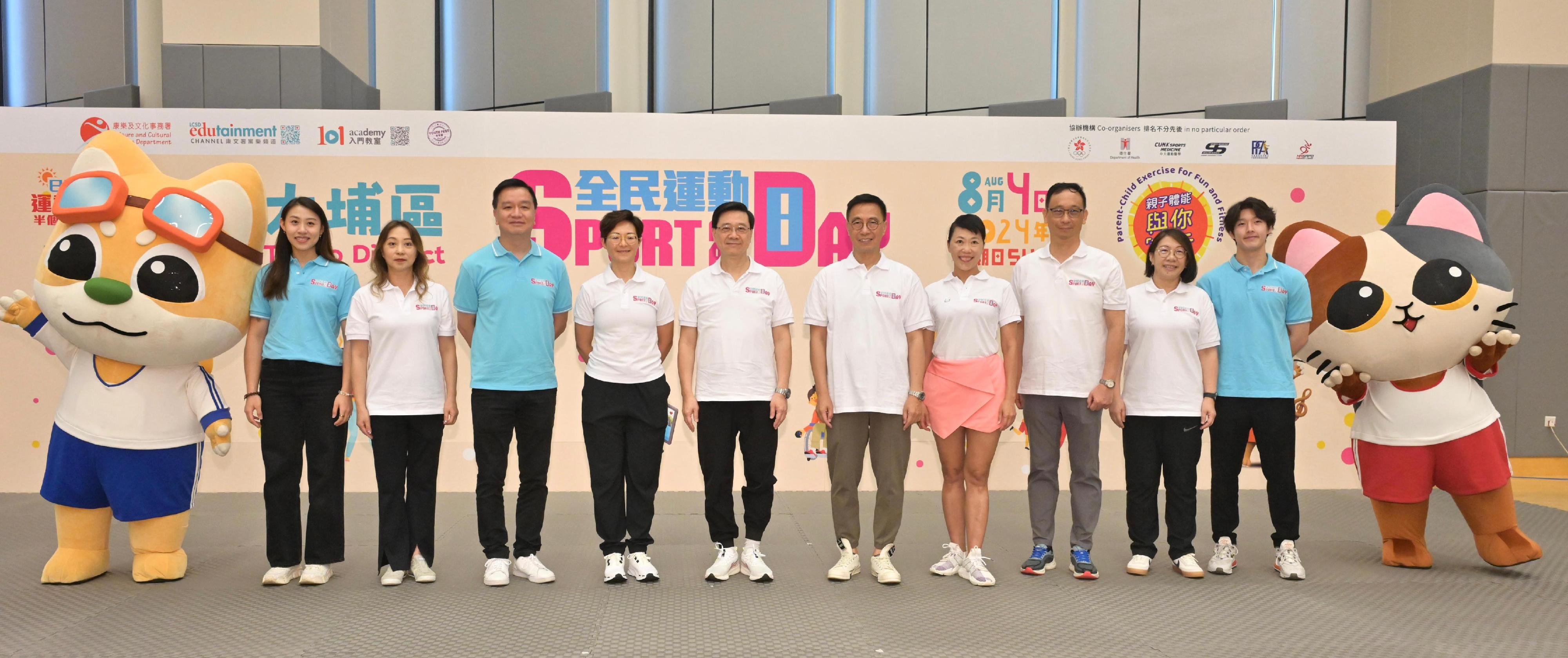 The Chief Executive, Mr John Lee, attended the Sport For All Day 2024 held by the Leisure and Cultural Services Department this afternoon (August 4) at the Tung Cheong Street Sports Centre, Tai Po, to promote the message of regular exercising for health. Photo shows Mr Lee (fifth left); the Secretary for Culture, Sports and Tourism, Mr Kevin Yeung (fifth right); the Acting Director of Leisure and Cultural Services, Miss Winnie Chui (fourth left); the Chairman of the Community Sports Committee, Professor Patrick Yung (third left); the District Officer (Tai Po), Ms Eunice Chan (fourth right); the Assistant Director of Leisure and Cultural Services (Leisure Services)1, Mr Henry Wong (third right); the Assistant Director of Leisure and Cultural Services (Leisure Services)2, Ms Camay Lee (second left); the Assistant Director of Leisure and Cultural Services (Leisure Services)3, Ms Fung Miu-ling (second right); karate athlete Tang Yu-hin (first right); and fencing athlete Kaylin Hsieh (first left) in front of a display board of the Sport For All Day 2024.