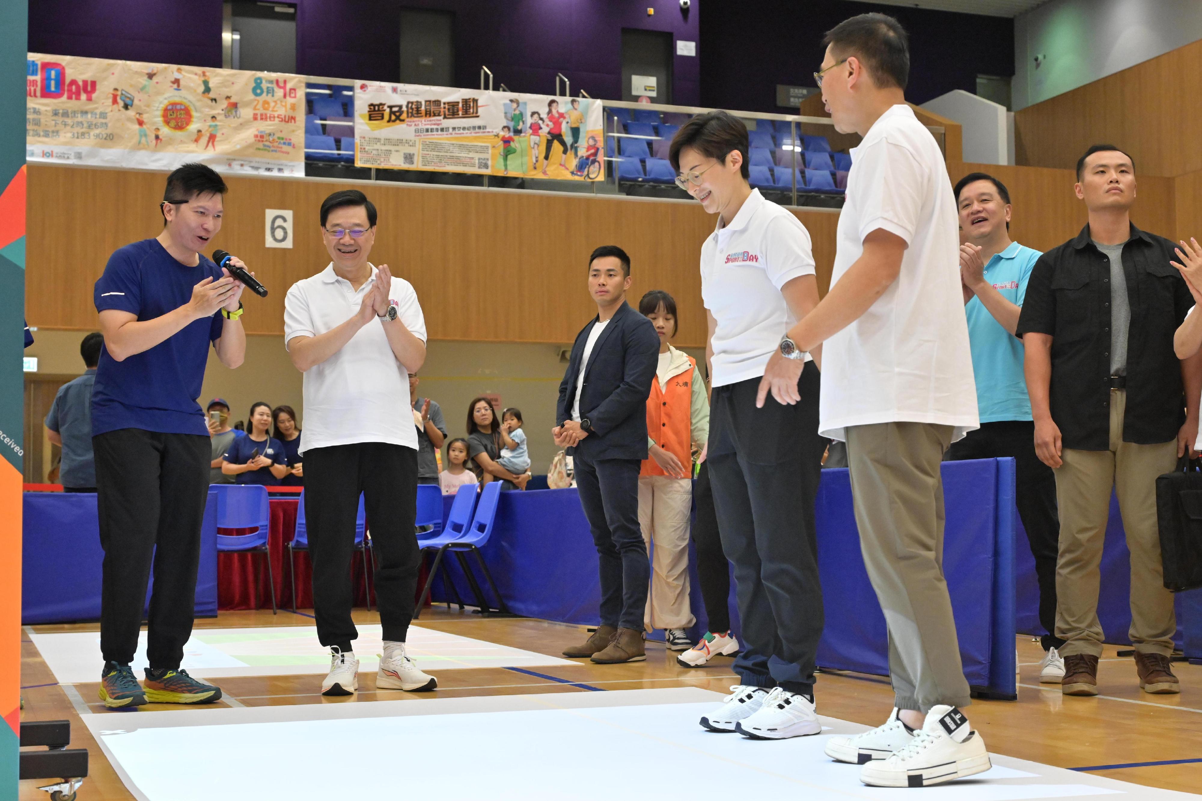 The Chief Executive, Mr John Lee, attended the Sport For All Day 2024 held by the Leisure and Cultural Services Department this afternoon (August 4) at the Tung Cheong Street Sports Centre, Tai Po, to promote the message of regular exercising for health. Photo shows Mr Lee (second left) watching the Acting Director of Leisure and Cultural Services, Miss Winnie Chui (second right); the Secretary for Culture, Sports and Tourism, Mr Kevin Yeung (first right), participating in the virtual game named “Dodge for Fun PLAY”.