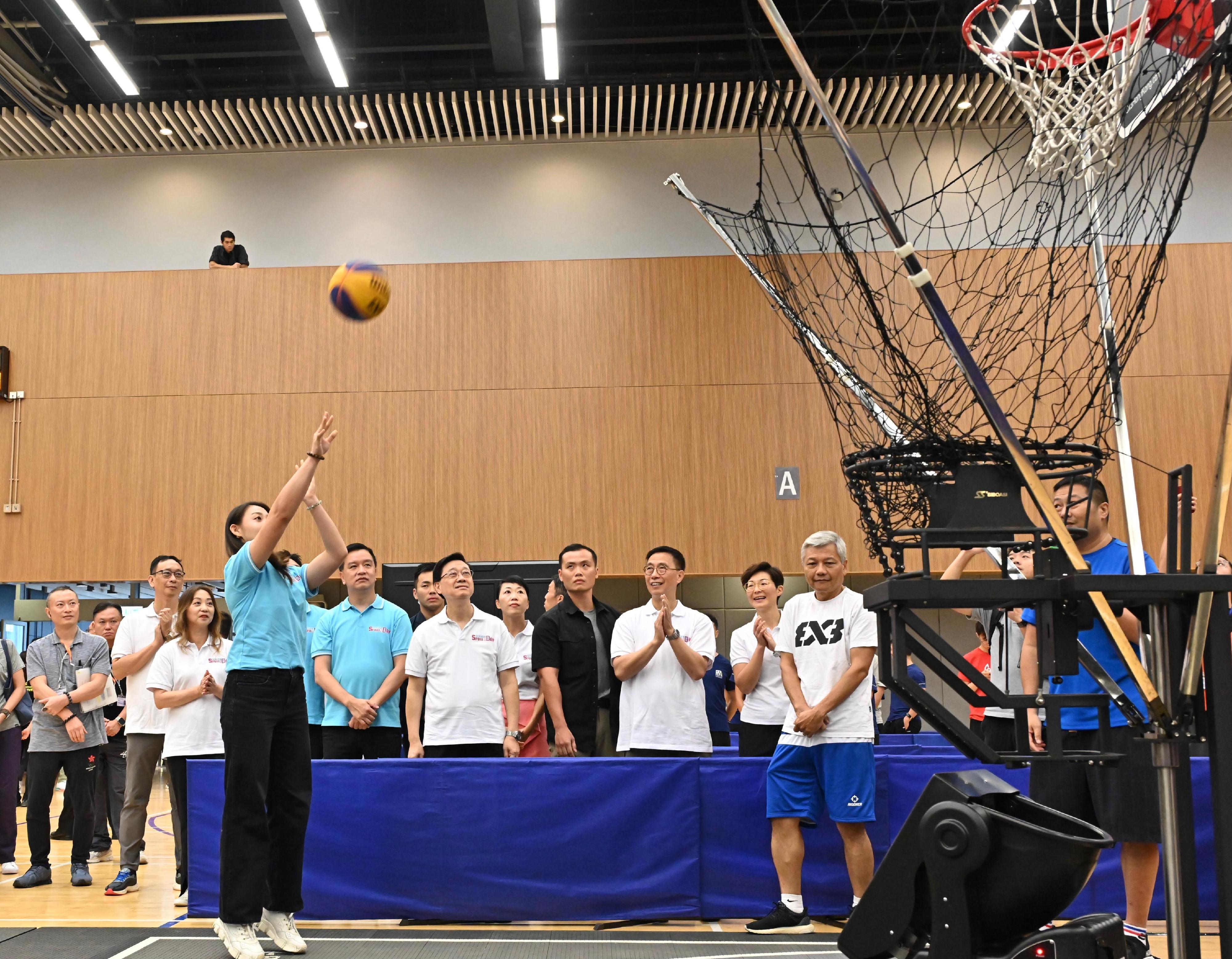 The Chief Executive, Mr John Lee, attended the Sport For All Day 2024 held by the Leisure and Cultural Services Department this afternoon (August 4) at the Tung Cheong Street Sports Centre, Tai Po, to promote the message of regular exercising for health. Photo shows Mr Lee (fifth right) watching fencing athlete Kaylin Hsieh (first left) in a parent-child 3-on-3 basketball demonstration.