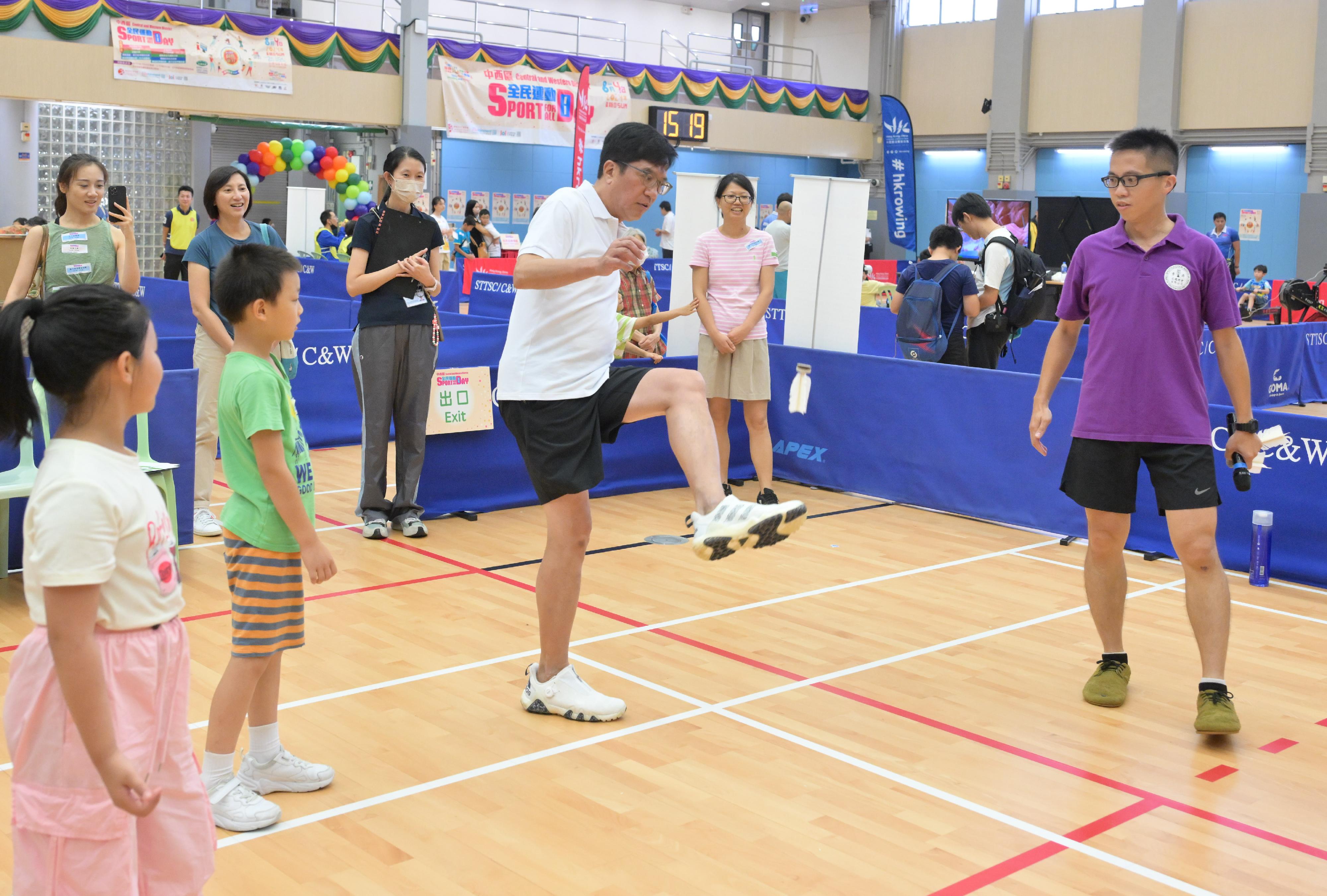 The Deputy Financial Secretary, Mr Michael Wong (second right), today (August 4) plays shuttlecock with the public participating in the Sport for All Day 2024 at the Shek Tong Tsui Sports Centre.