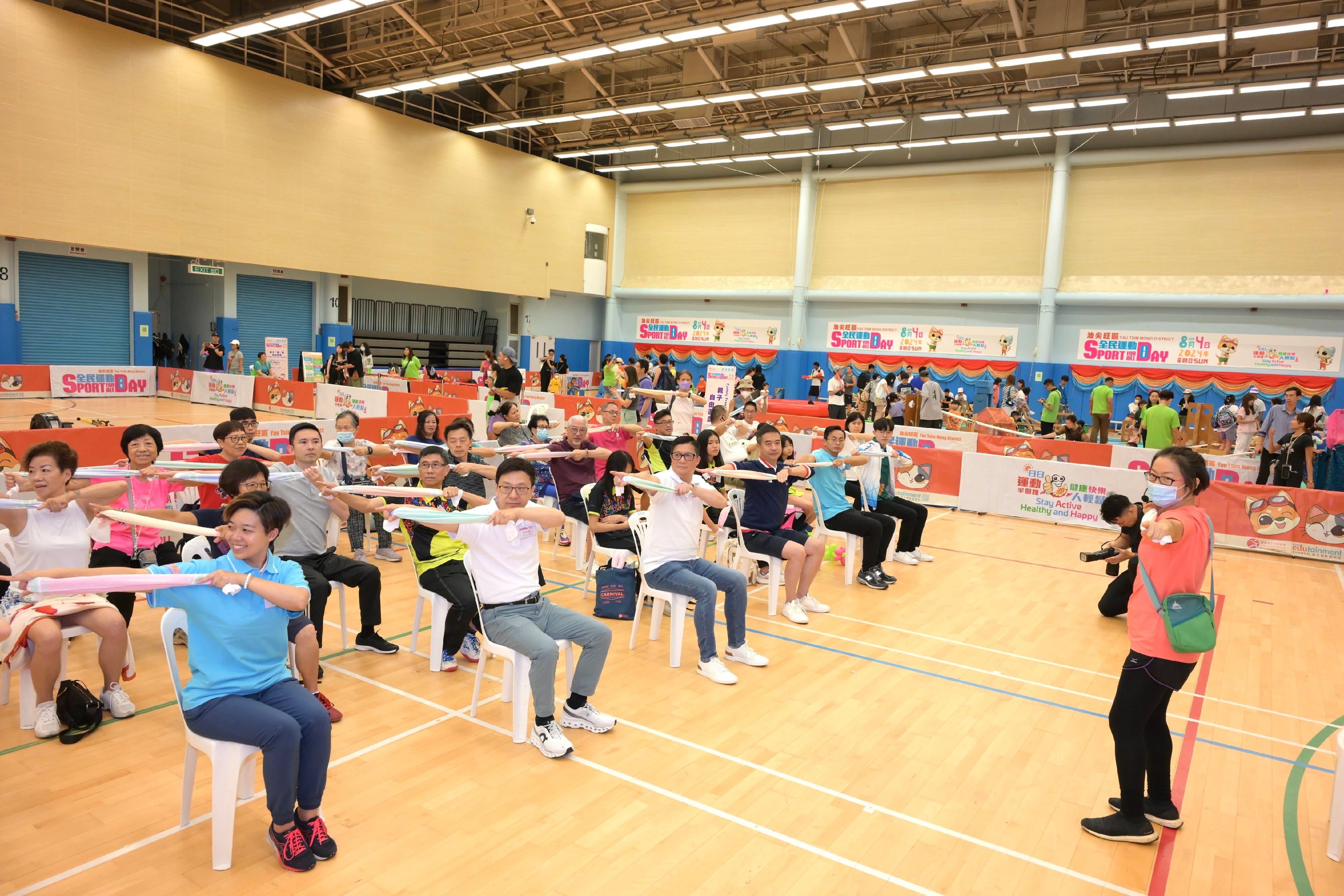 The Secretary for Security, Mr Tang Ping-keung, and the Secretary for Labour and Welfare, Mr Chris Sun, joined the public for sports and recreation programmes at Kowloon Park Sports Centre this afternoon (August 4) as part of the Sport For All Day 2024 organised by the Leisure and Cultural Services Department. Photo shows Mr Tang (front row, third left) and Mr Sun (front row, second left) participating in towel fitness exercise with participants.
