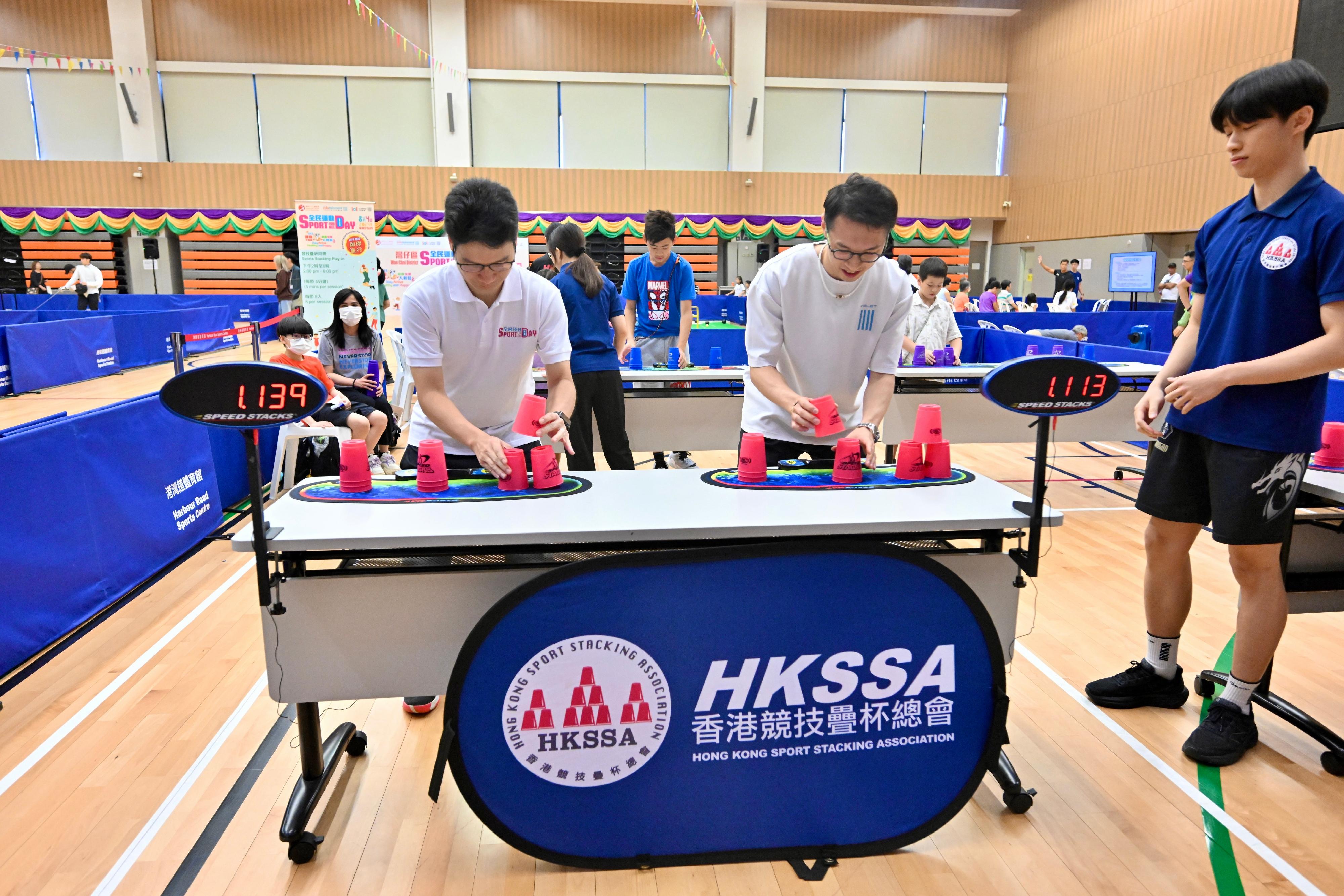 The Acting Secretary for Financial Services and the Treasury, Mr Joseph Chan, joined the Sport For All Day 2024 activities at the Harbour Road Sports Centre today (August 4). Photo shows Mr Chan (left) playing speed stacks with the badminton athlete Mr Angus Ng (right).