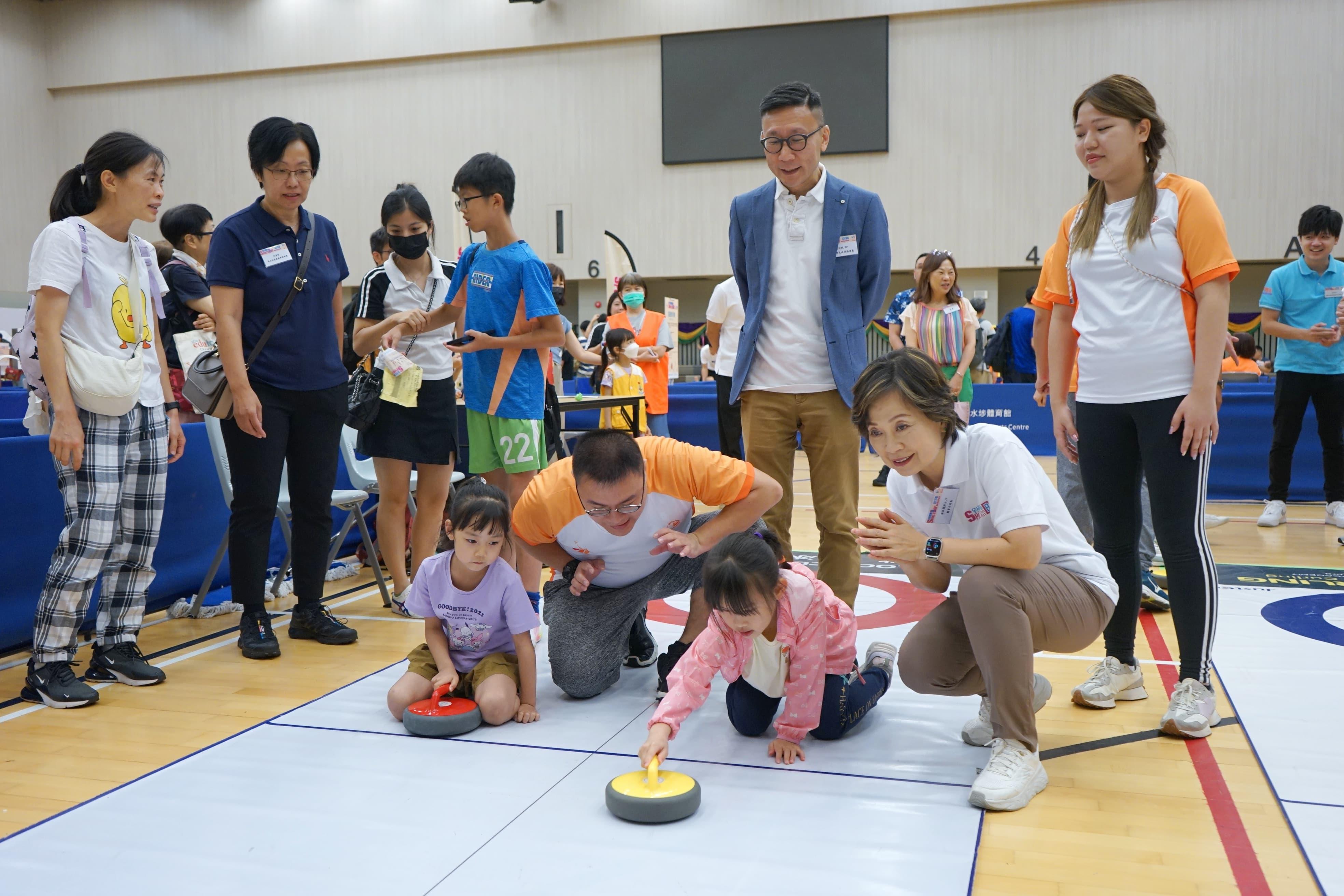 The Secretary for Education, Dr Choi Yuk-lin, participated in the Sport For All Day 2024 activities held by the Leisure and Cultural Services Department at the Sham Shui Po Sports Centre this afternoon (August 4). Photo shows Dr Choi (second right) participating in a floor curling session with the public.