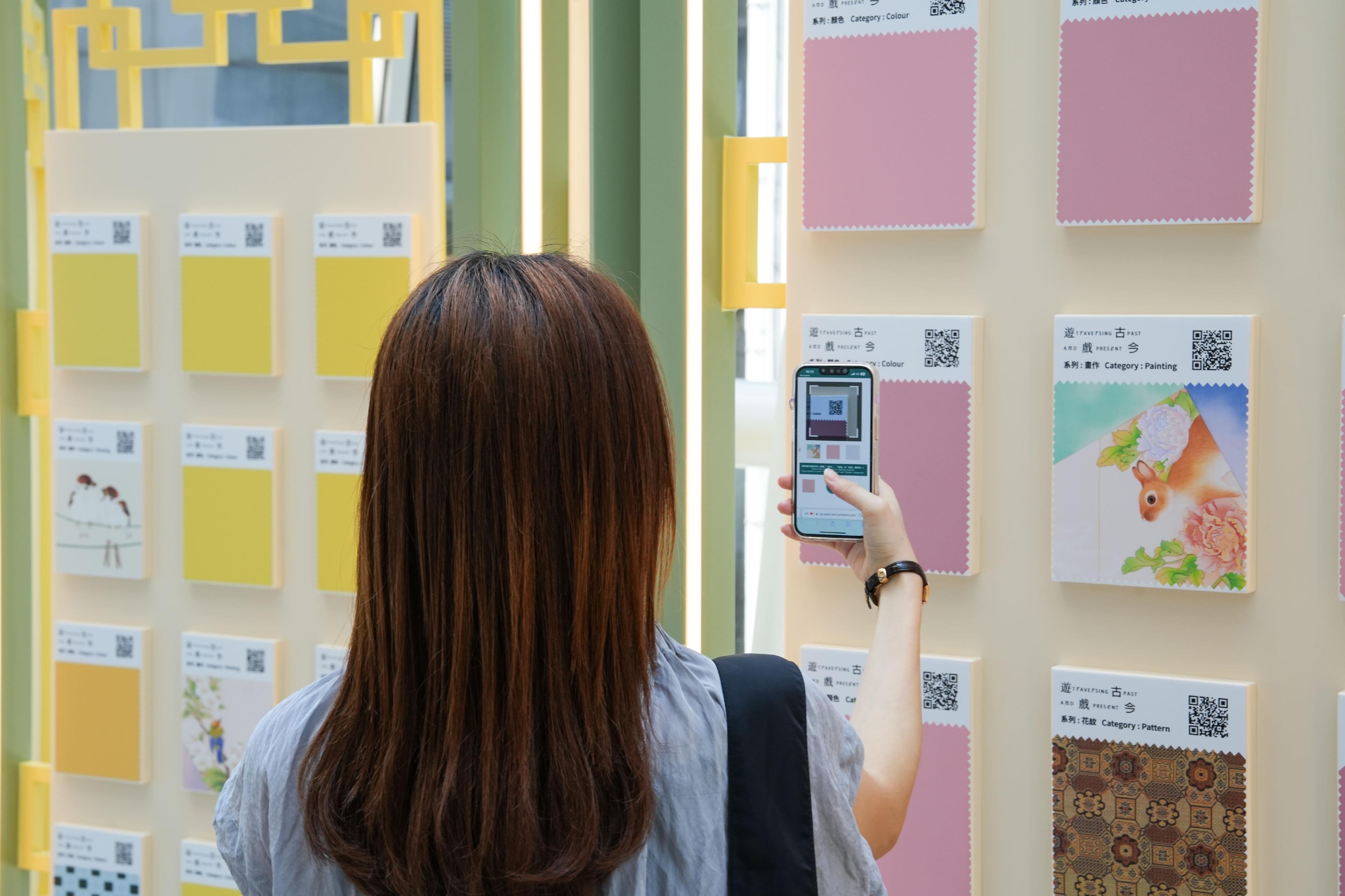 In collaboration with Hong Kong International Airport (HKIA), the Art Promotion Office under the Leisure and Cultural Services Department launched the "Traversing Past and Present" exhibition as part of the HKIA Arts & Culture Festival 2024. The exhibition is now on display from today (August 8) until October 31 at HKIA Terminal 1. Photo shows a visitor using augmented reality technology through a custom website created by designer Jack Lau to interact with the artwork.