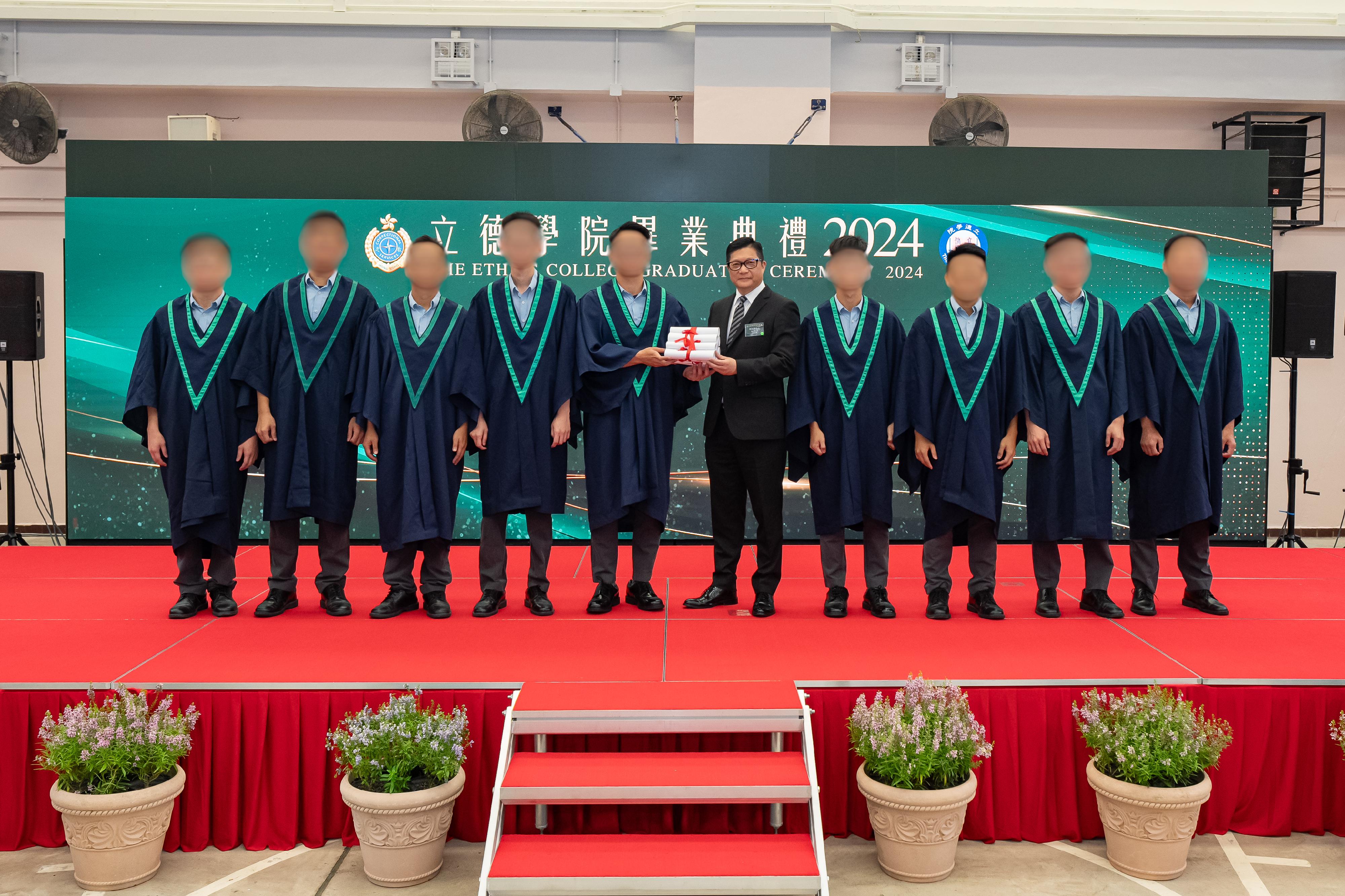 The Correctional Services Department held the first graduation ceremony of the Ethics College at Pak Sha Wan Correctional Institution today (August 8) to present graduation certificates to persons in custody who have completed the Diploma of Applied Education programme. Photo shows the Secretary for Security, Mr Tang Ping-keung (fifth right), presenting graduation certificates to persons in custody.