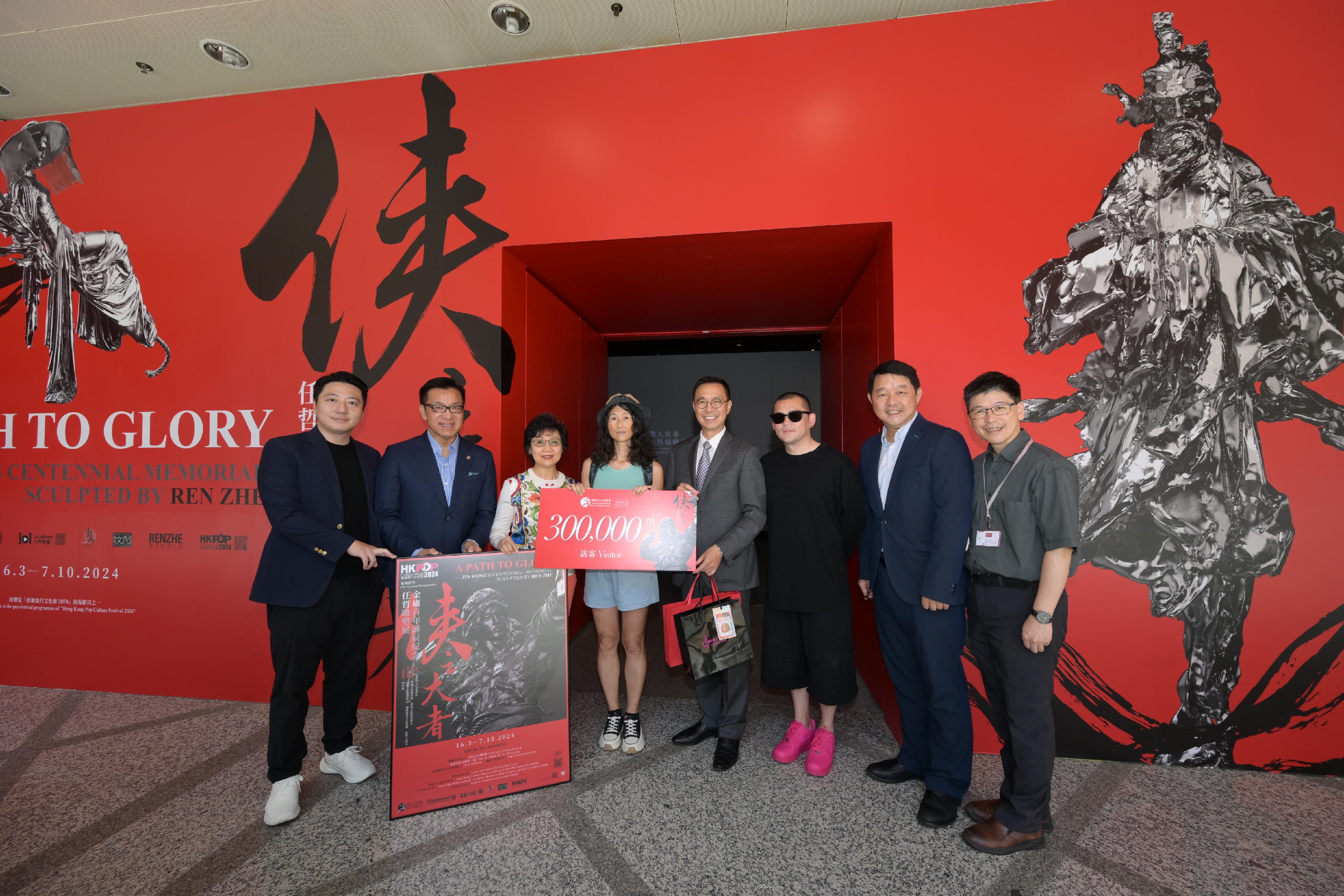 The "A Path to Glory - Jin Yong's Centennial Memorial, Sculpted by Ren Zhe" exhibition organised by the Hong Kong Heritage Museum (HKHM), open for nearly five months, has been popular among the local public and tourists, with a cumulative attendance of over 300 000. Photo shows the Secretary for Culture, Sports and Tourism, Mr Kevin Yeung (fourth right); the co-curator of the exhibition and Founder of Guyu Cultural Development Foundation, Mr William Fong (first left); sculptor Ren Zhe (third right); the Vice-Chairman of the Hong Kong Arts Development Council, Dr Frankie Yeung (second left); Cantopop singer Ms Teresa Cheung (third left); the Museum Director of the HKHM, Mr Brian Lam (second right); and the Curator (Art) of the HKHM, Dr Raymond Tang (first right), welcoming the 300 000th visitor of the exhibition and presenting a gift pack to her today (August 9).