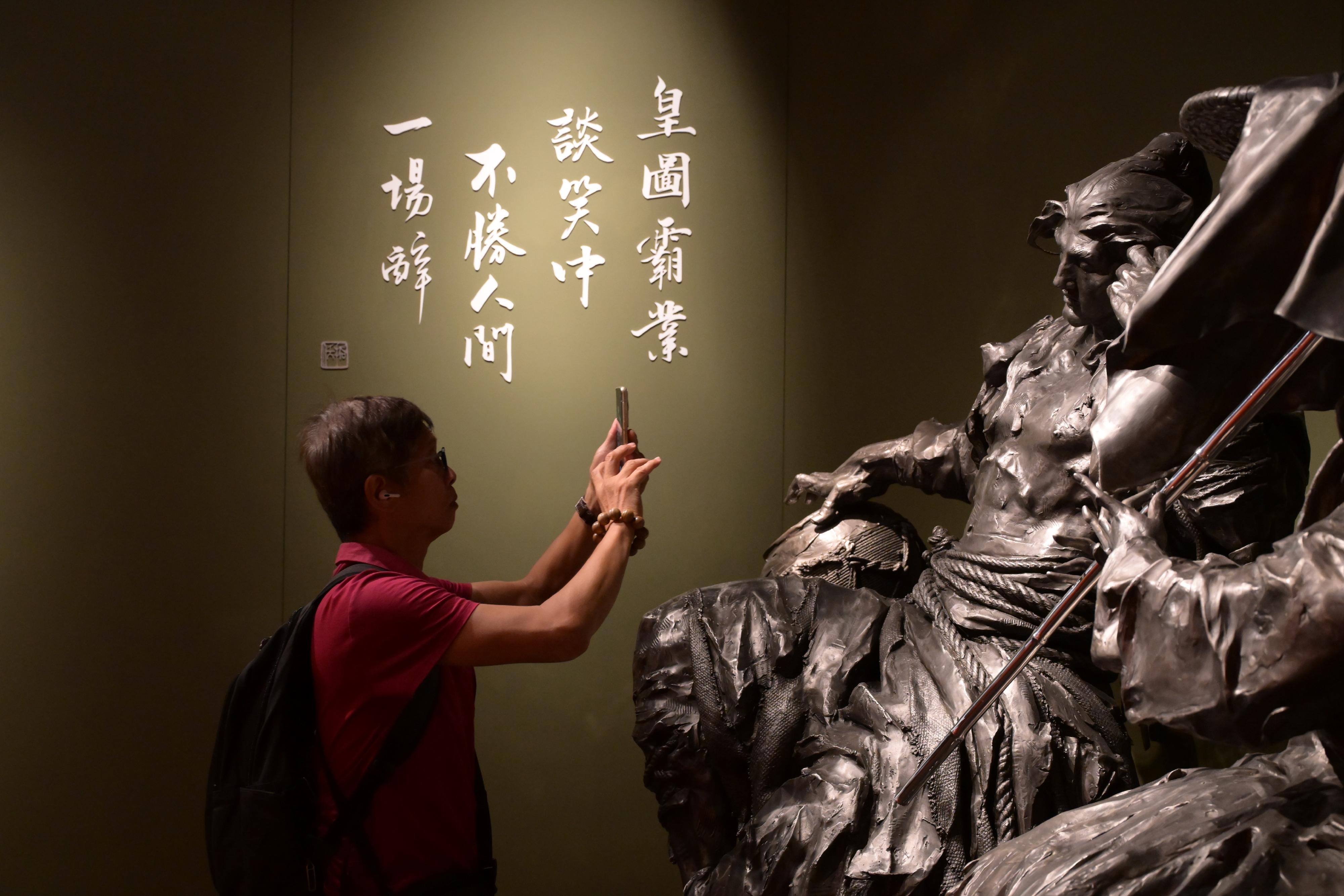 The "A Path to Glory - Jin Yong's Centennial Memorial, Sculpted by Ren Zhe" exhibition organised by the Hong Kong Heritage Museum, open for nearly five months, has been popular among the local public and tourists, with a cumulative attendance of over 300 000. Photo shows a visitor touring the exhibition.