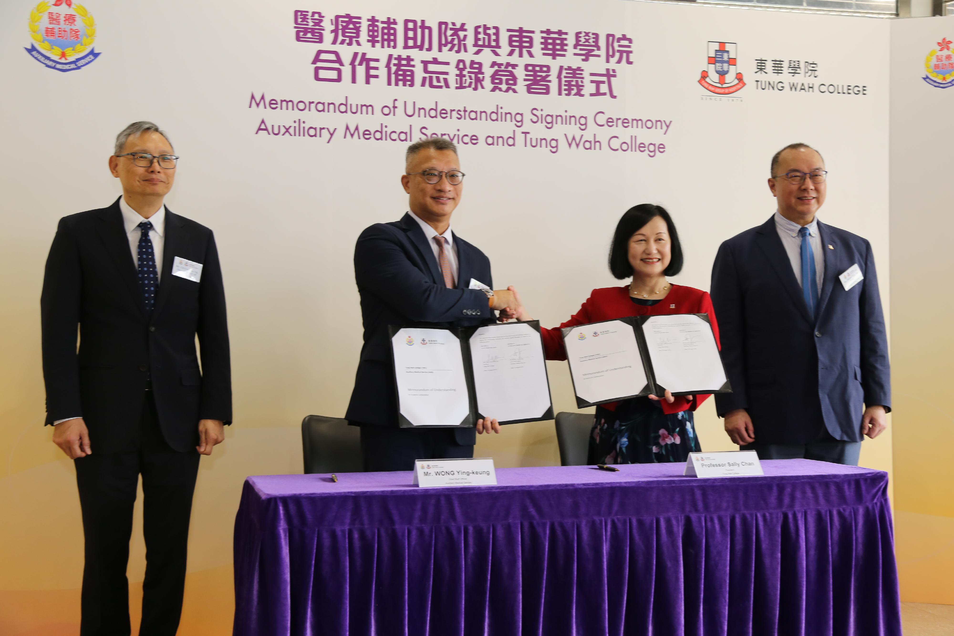 The Auxiliary Medical Service (AMS) and Tung Wah College (TWC) signed a Memorandum of Understanding (MOU) today (August 10) to officially launch a series of programmes regarding youth nurturing and development. Witnessed by the Under Secretary for Security, Mr Michael Cheuk (first left), and the Chairman of the College Council of TWC, Mr York Tseng (first right), the MOU was signed by the Chief Staff Officer of the AMS, Mr Wong Ying-keung (second left), and the President of TWC, Professor Sally Chan (second right).