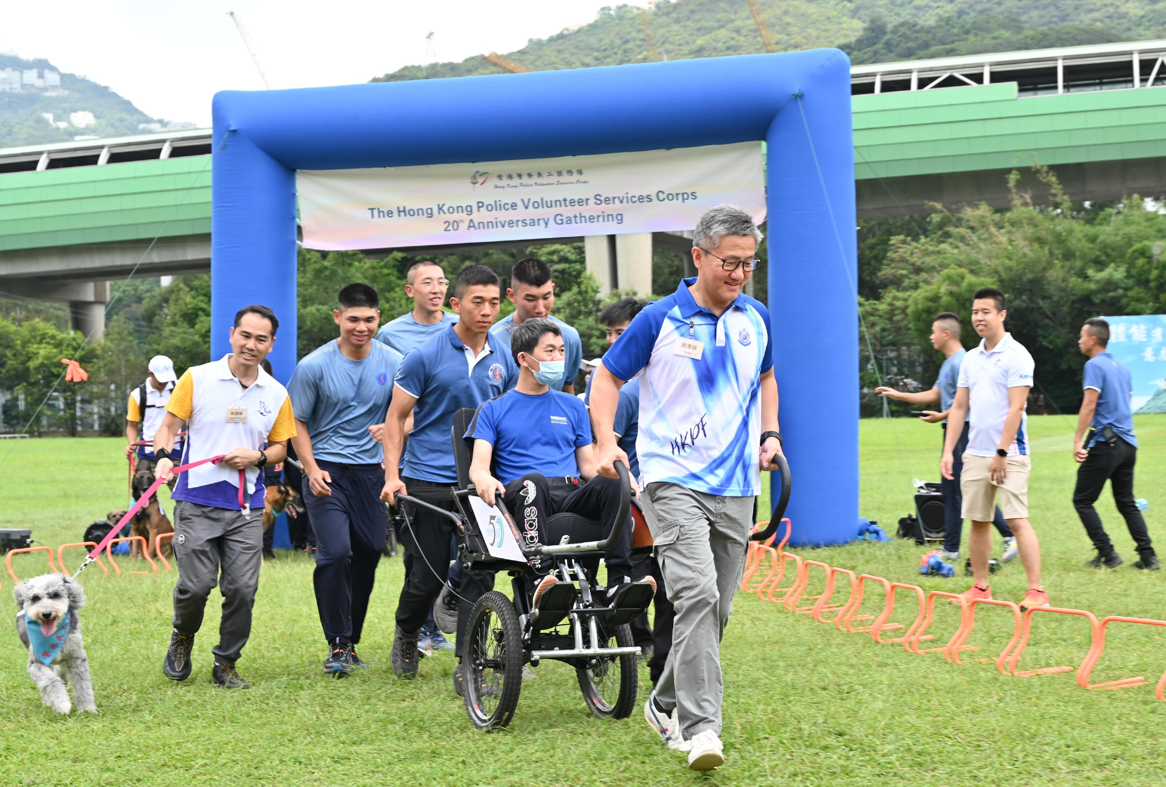 Hong Kong Police Volunteer Services Corps held a gathering at the Hong Kong Police College to commemorate their 20th anniversary today (August 10). Photo shows the Commissioner of Police, Mr Siu Chak-yee, participating in an activity titled "Our Days at Police College - Wheelchair Rickshaw Volunteer Service" and pulling a specially designed wheelchair rickshaw to carry service recipients as passengers.