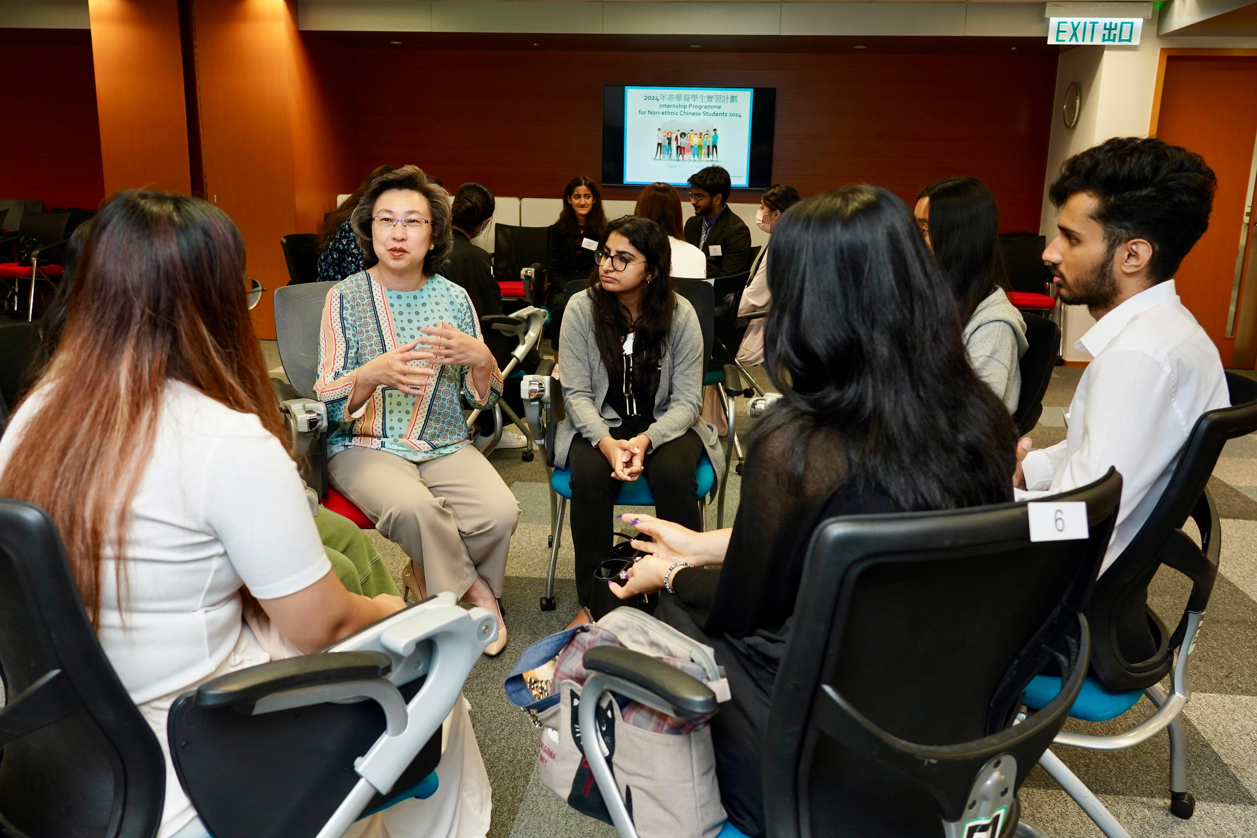 The Secretary for the Civil Service, Mrs Ingrid Yeung, attended a sharing session on the Internship Programme for Non-ethnic Chinese Students today (August 12). Photo shows Mrs Yeung (first left) chatting with interns to learn about their internship experiences and takeaways.