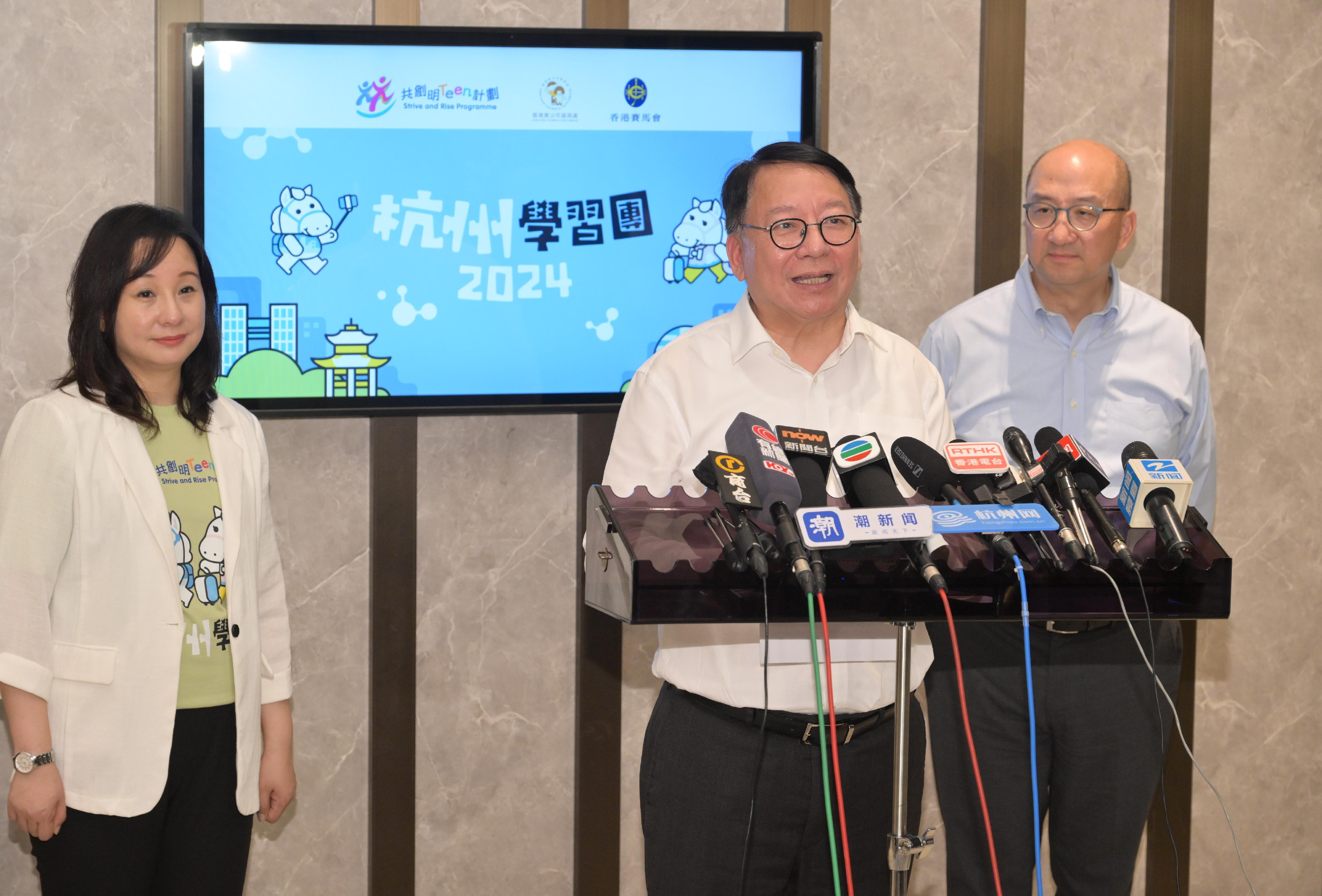 The Chief Secretary for Administration, Mr Chan Kwok-ki, visited Hangzhou today (August 12). Photo shows Mr Chan (centre), accompanied by the Executive Director of
Corporate Affairs of The Hong Kong Jockey Club, Mr Raymond Tam (right), and the Agency Director of Hong Kong Children & Youth Services, Ms Joyce Lee (left), speaking to the media in Hangzhou.